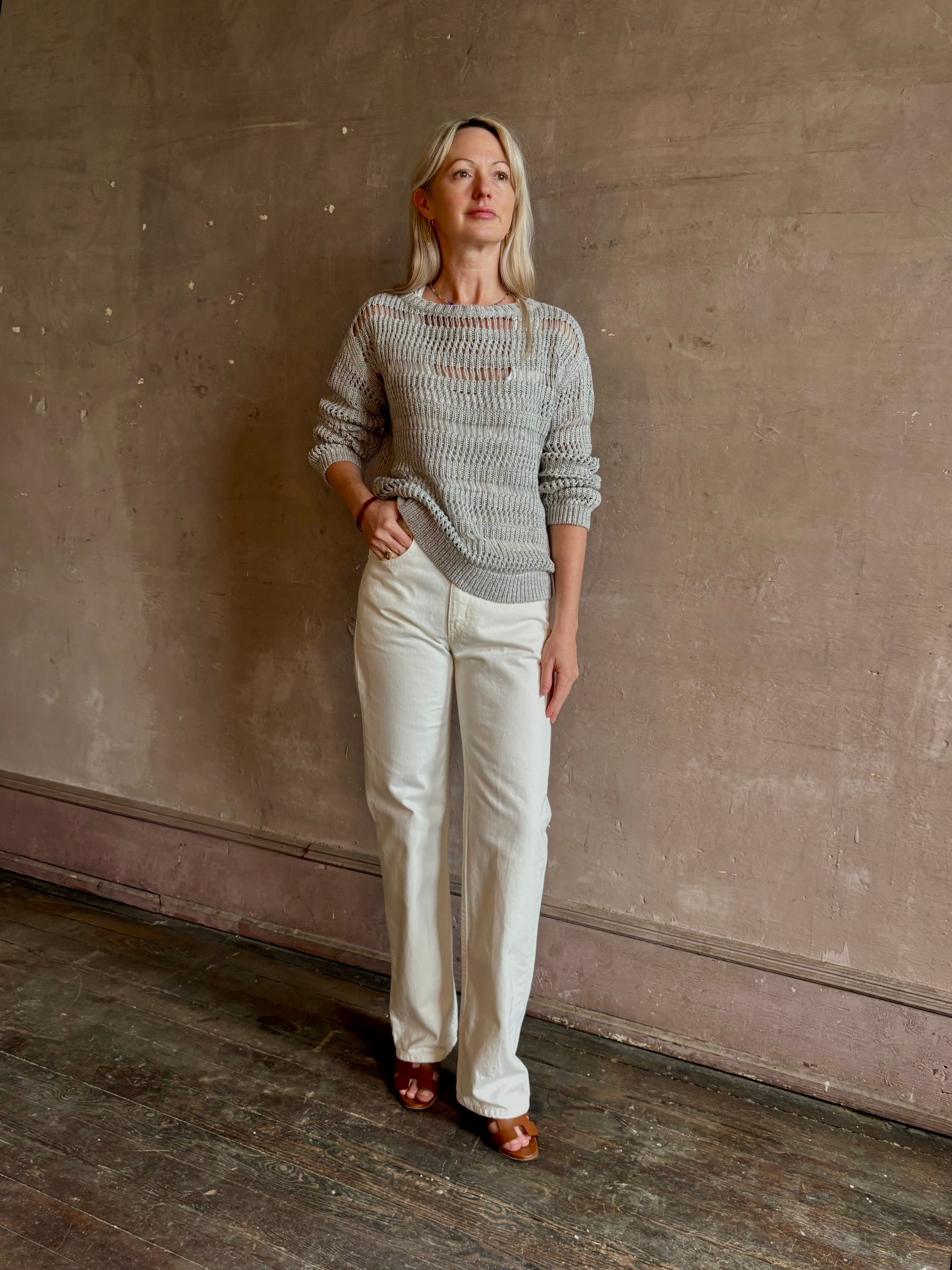 Mature woman wearing luxury Kent St modern Denim from TWP rendered in a pristine white and crafted from 100% cotton in the USA with a straight leg, high-rise and zipper closure
