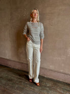 Mature woman wearing luxury Kent St modern Denim from TWP rendered in a pristine white and crafted from 100% cotton in the USA with a straight leg, high-rise and zipper closure