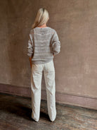 Mature woman wearing luxury Kent St modern Denim from TWP rendered in a pristine white and crafted from 100% cotton in the USA with a straight leg, high-rise and zipper closure