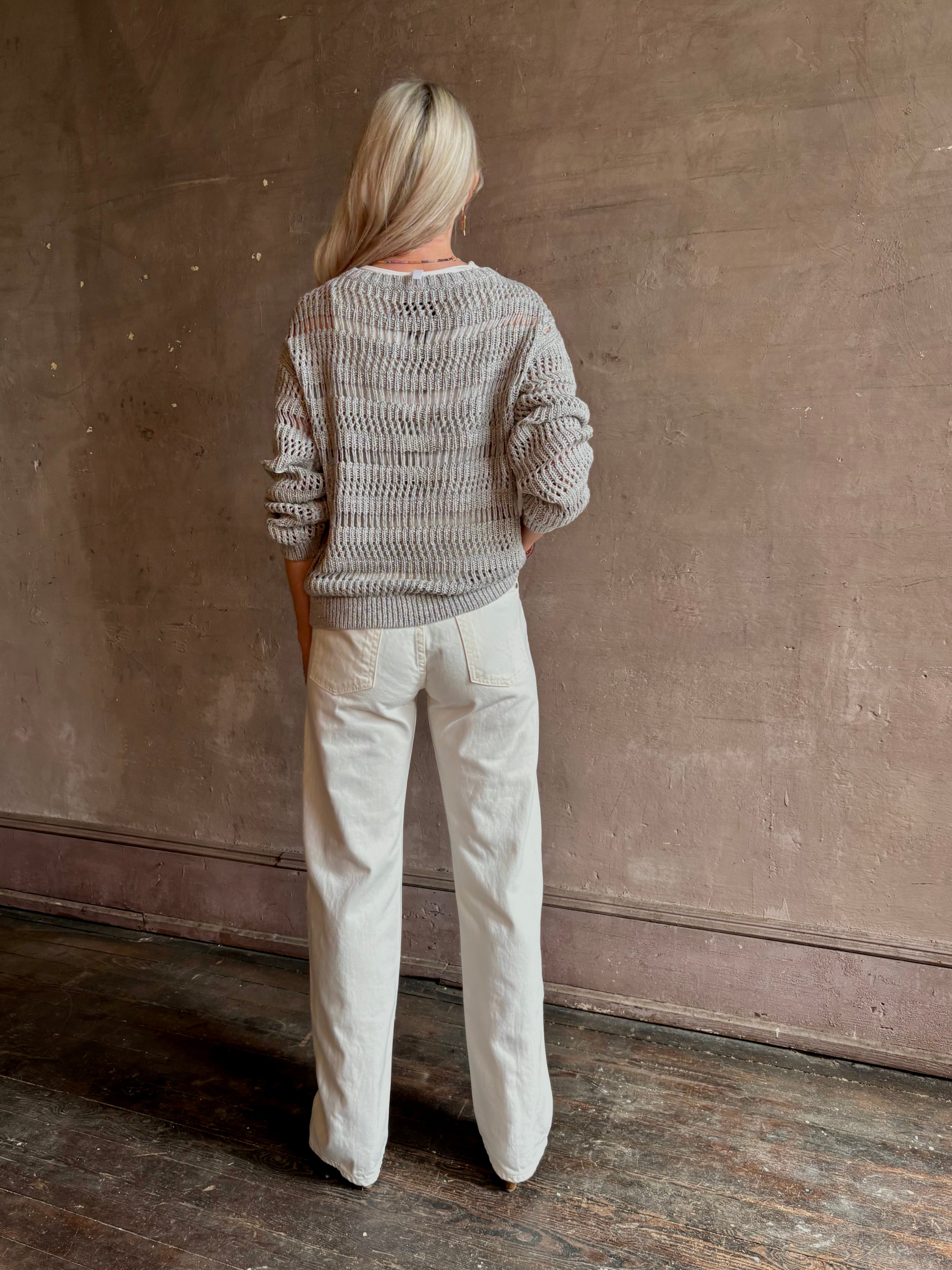 Mature woman wearing luxury Kent St modern Denim from TWP rendered in a pristine white and crafted from 100% cotton in the USA with a straight leg, high-rise and zipper closure