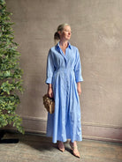 Mature woman wearing TWP M Dress, luxury women's superfine cotton dress  button-front closure with pleats blue