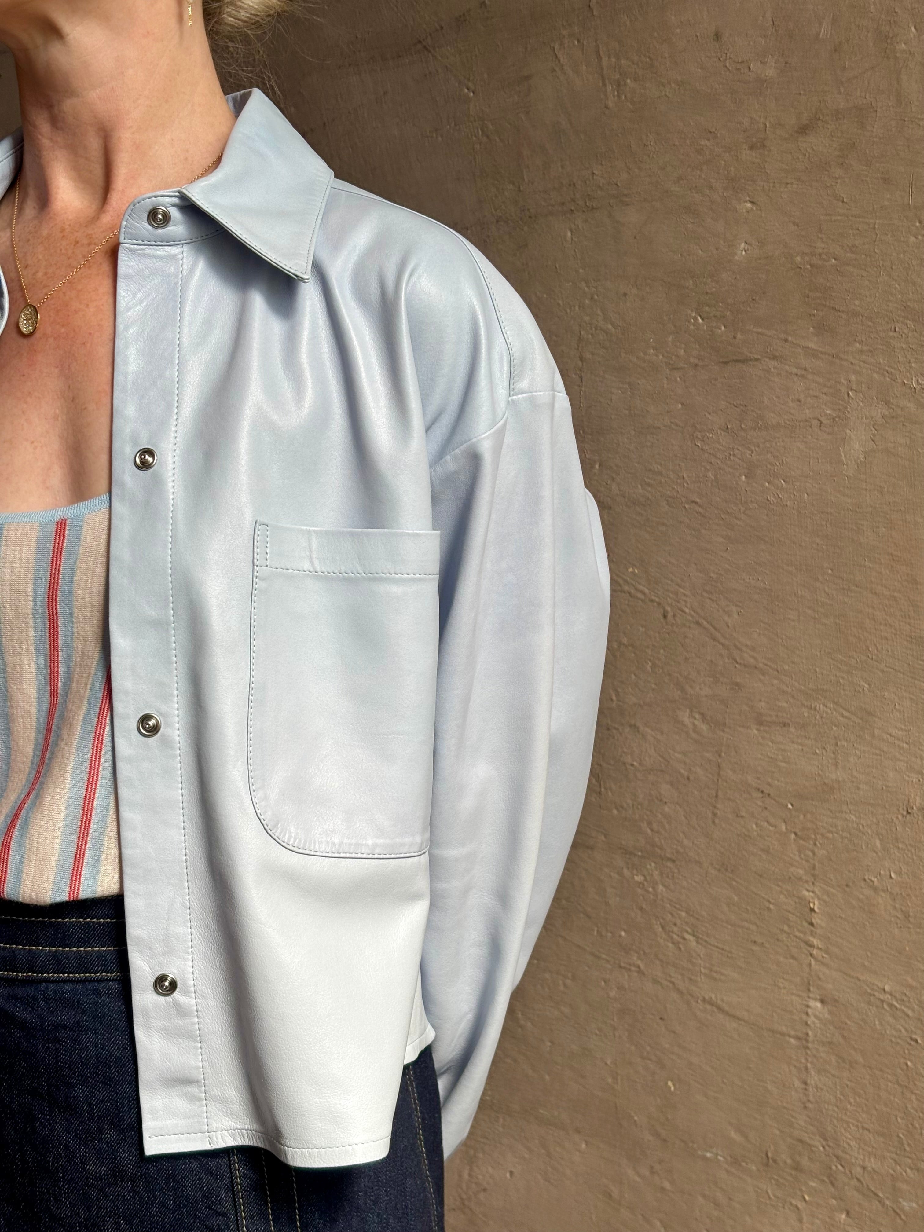 Mature woman reviewing premium lambskin leather TWP Little Big Joe button down cropped Shirt or Jacket in Kentucky Blue with long sleeves