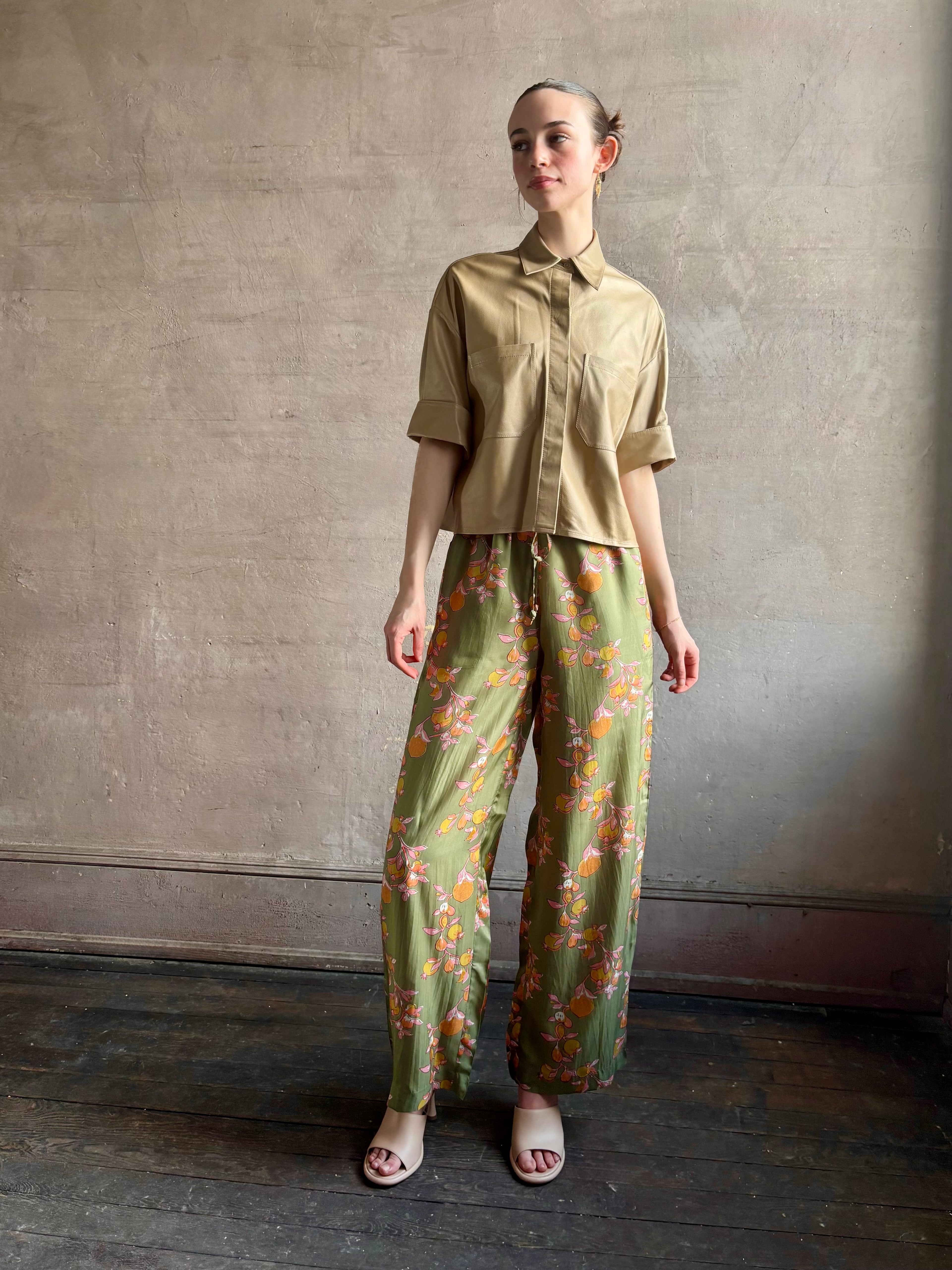 Woman wearing luxury designer TWP premium Lambskin Leather button up collared shirt with cuffed short sleeves in a neutral khaki that can double as a lightweight jacket