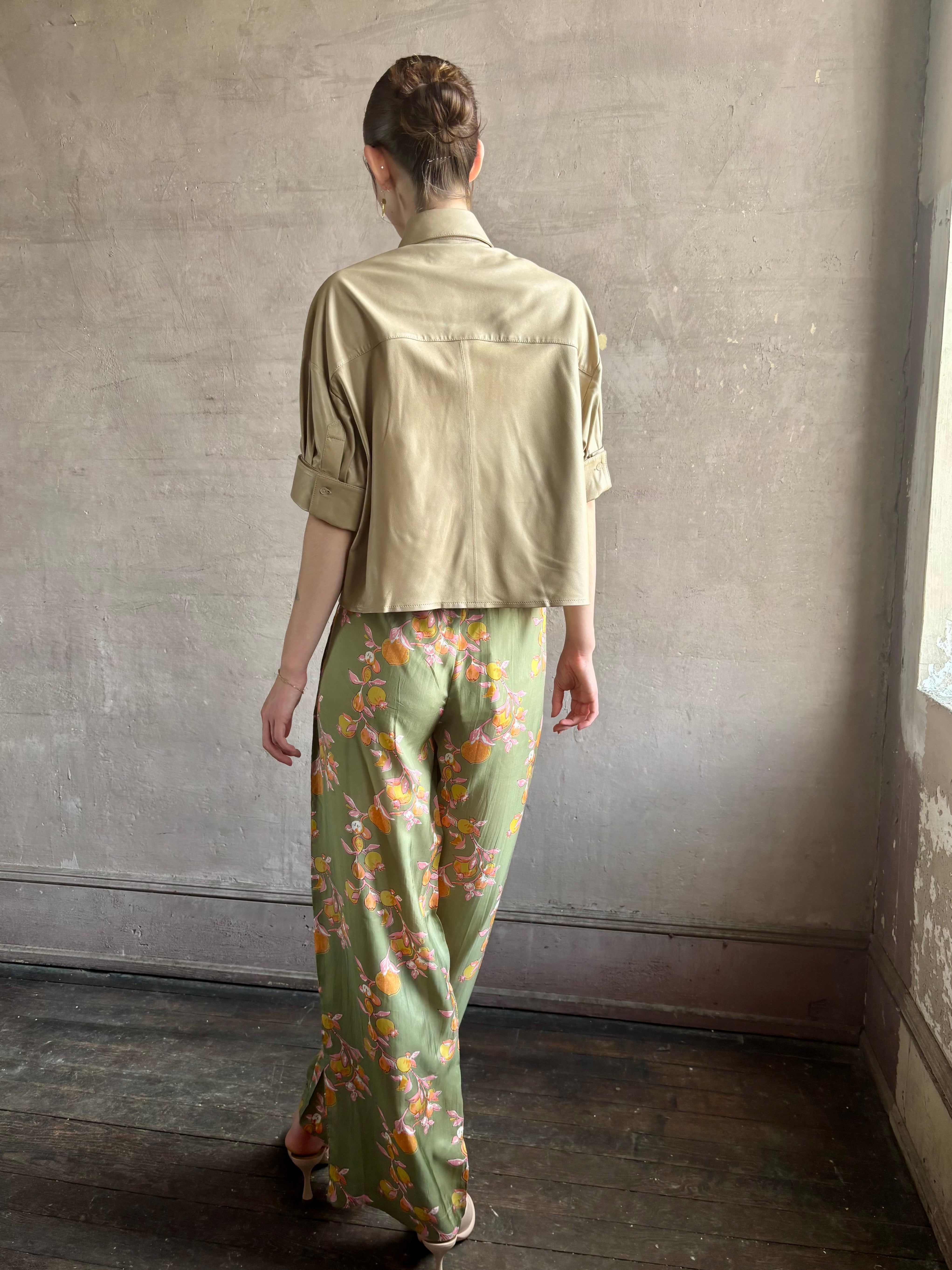 Woman wearing luxury designer TWP premium Lambskin Leather button up collared shirt with cuffed short sleeves in a neutral khaki that can double as a lightweight jacket