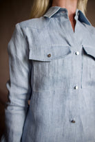 Mature woman wearing luxury TWP New Carter indigo Button Up hemp top combining timeless workwear with contemporary refinement with long sleeves, metal buttons, collar and front pockets