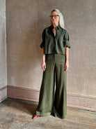 Mature woman wearing TWP next ex cotton poplin dark green rosin button-up shirt with rolled sleeves and collar