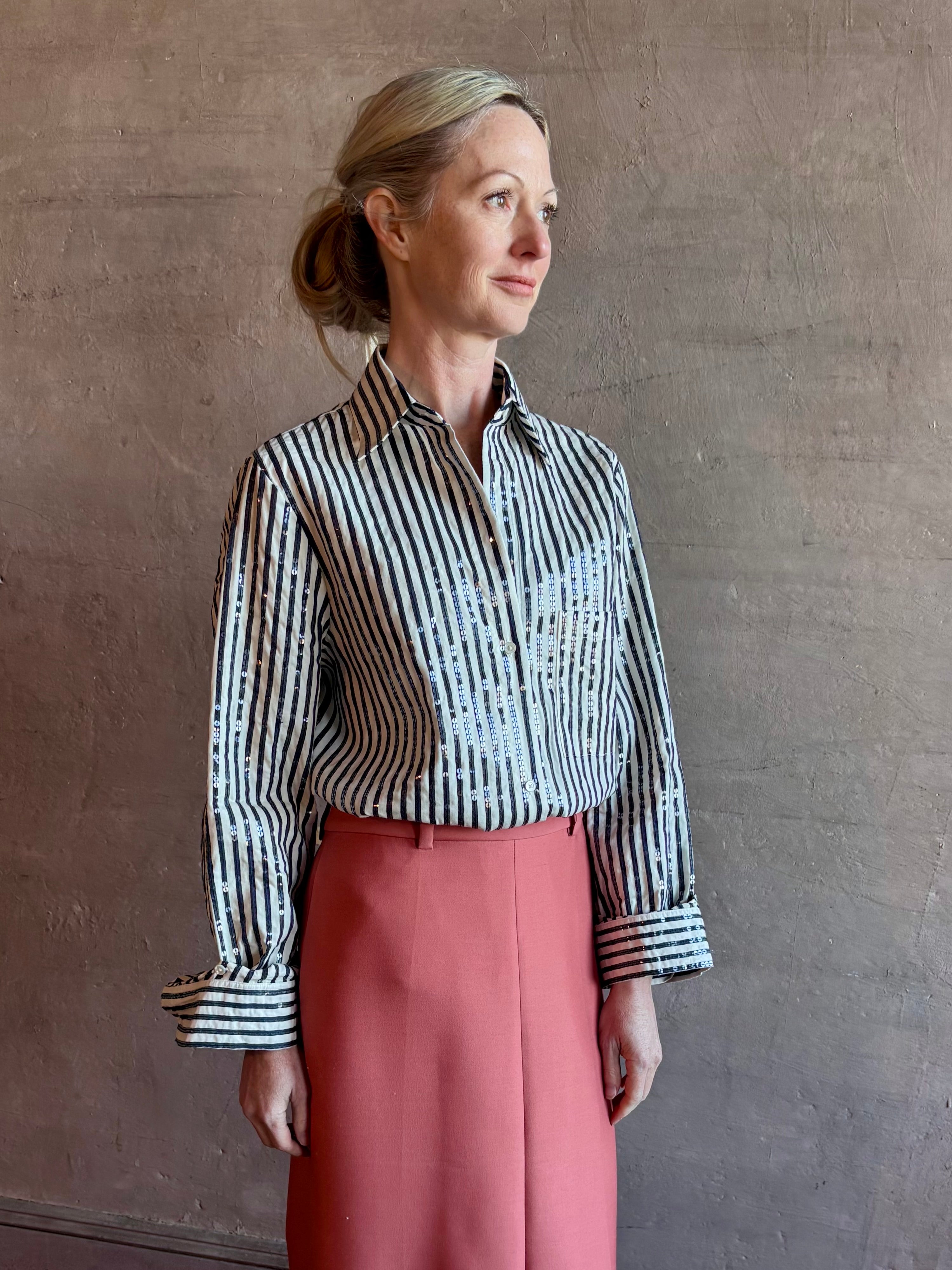 Mature woman wearing TWP premium cotton-blend button down indigo striped shirt with sequins, long sleeve and collar