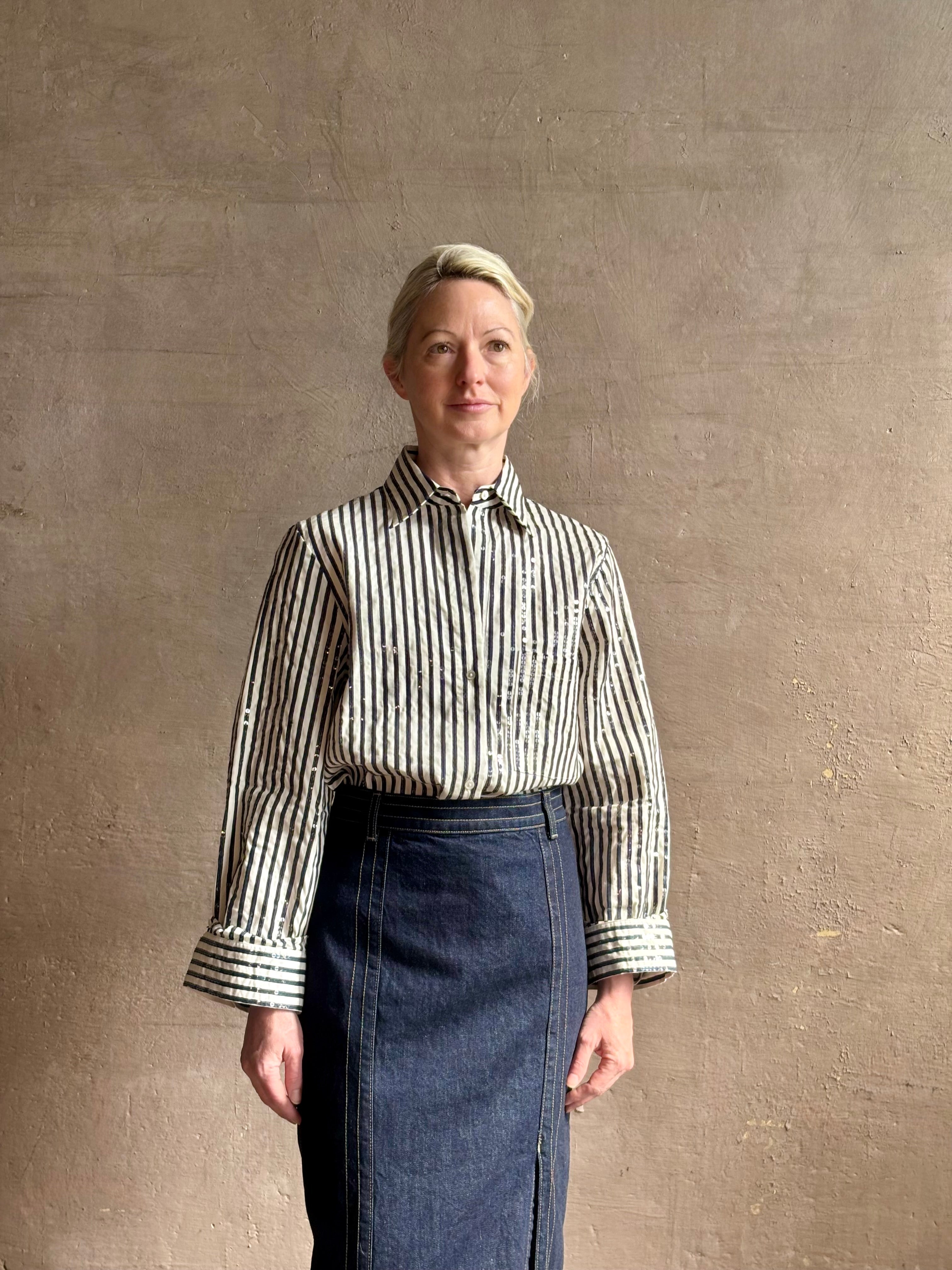 Mature woman wearing TWP premium cotton-blend button down indigo striped shirt with sequins, long sleeve and collar
