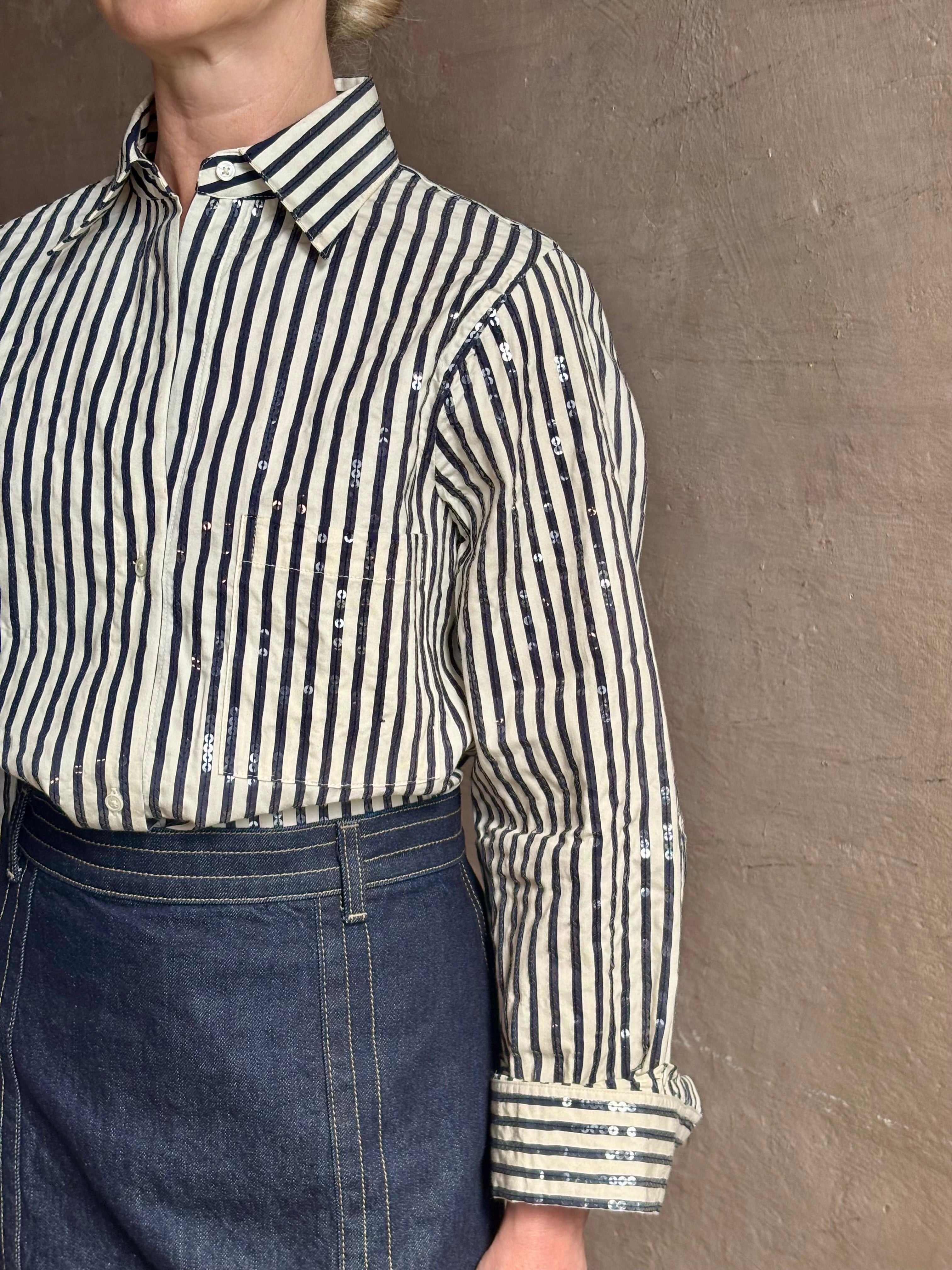 Mature woman wearing TWP premium cotton-blend button down indigo striped shirt with sequins, long sleeve and collar