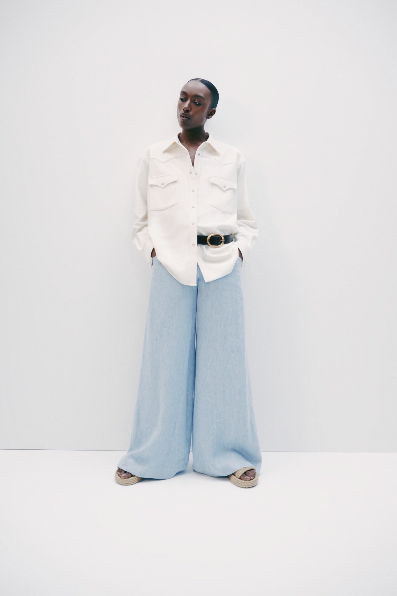 Model wearing luxury brand TWP Demie High Rise wide leg indigo hemp Pants offers timeless  refinement and expert craftsmanship