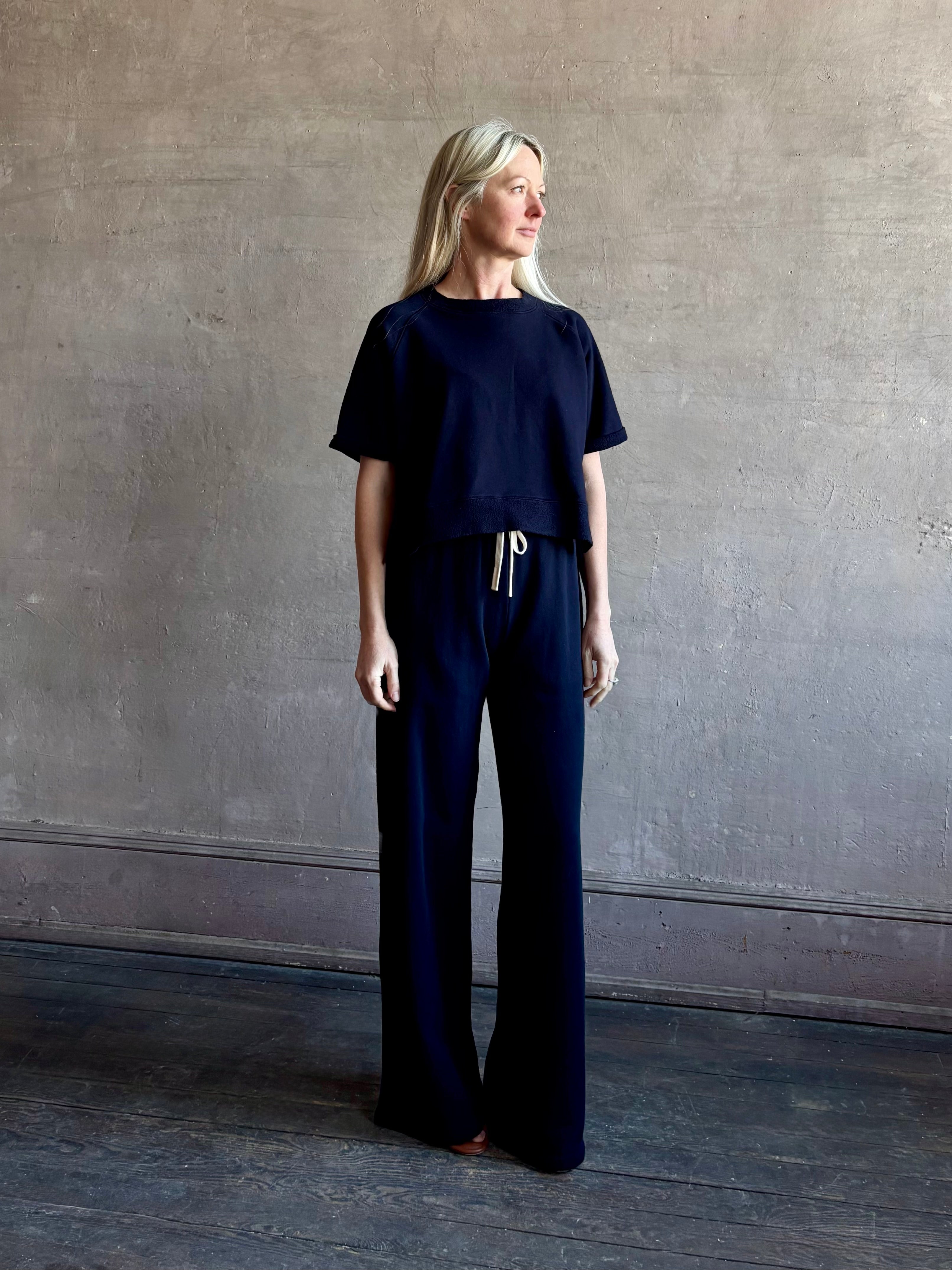 Mature woman wearing the PJ Pant from TWP is a luxuriously relaxed women's designer lounge pant crafted from cotton with a straight leg and effortless pull-on waist 