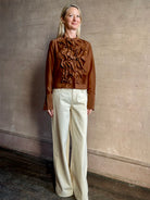 Image of woman wearing premium cotton silk TWP Patti Blouse in Emperador brown with ruffle front and long sleeves