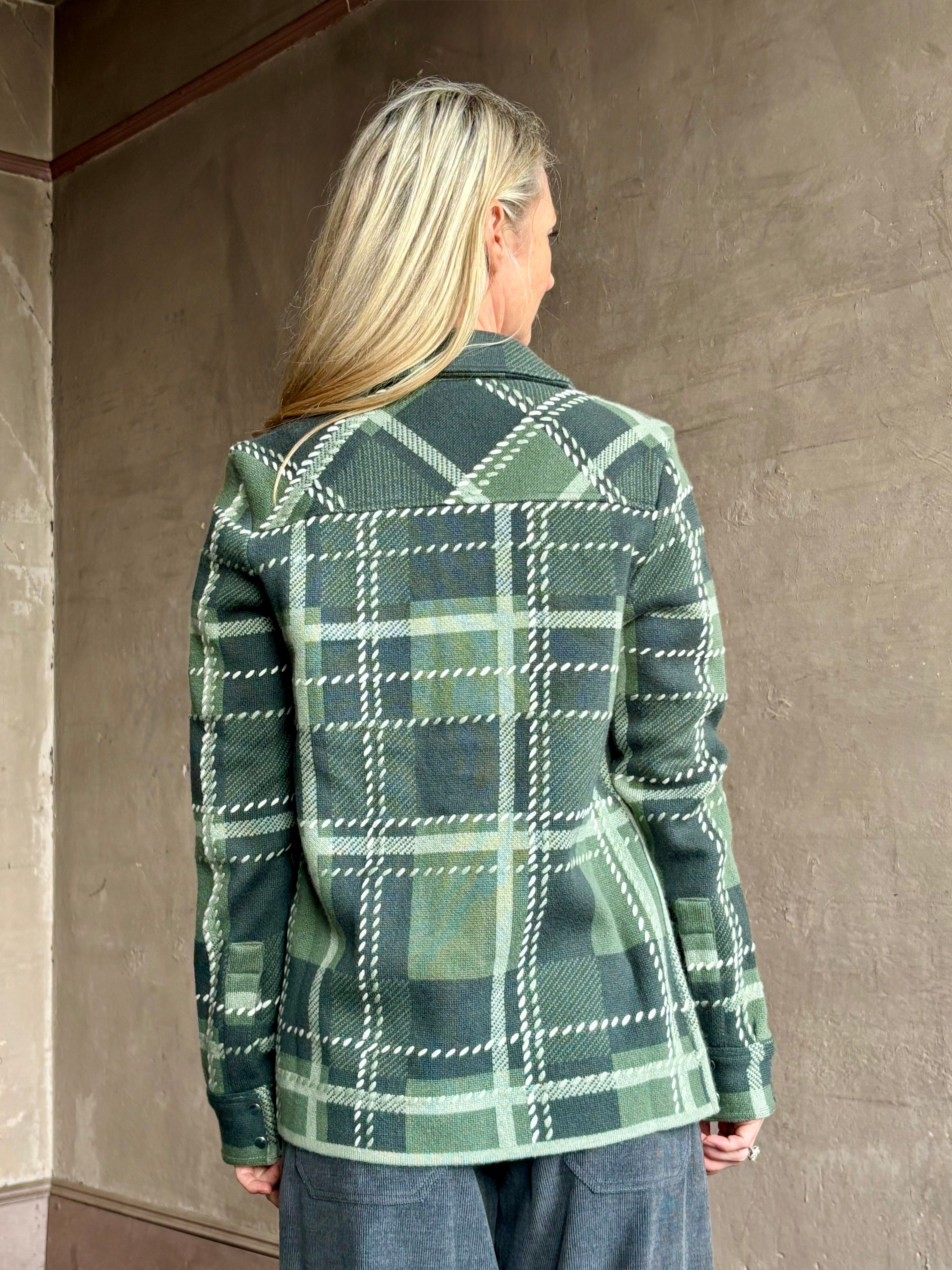 Image of mature woman wearing mountain-inspired comfort TWP ranchers cardigan in classic green plaid perfect for layering