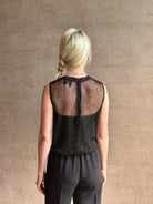 Image of mature woman wearing Women's designer clothing label TWP short muscle tank in black with subtle sequin embellishments perfect for luxury layering 