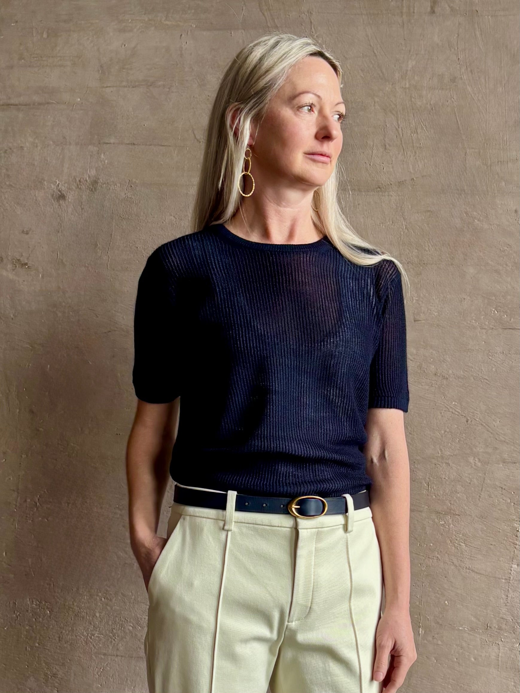 Mature woman wearing luxury Short Sleeve navy blue cashmere Tee Sweater from TWP with open weave and crew neck