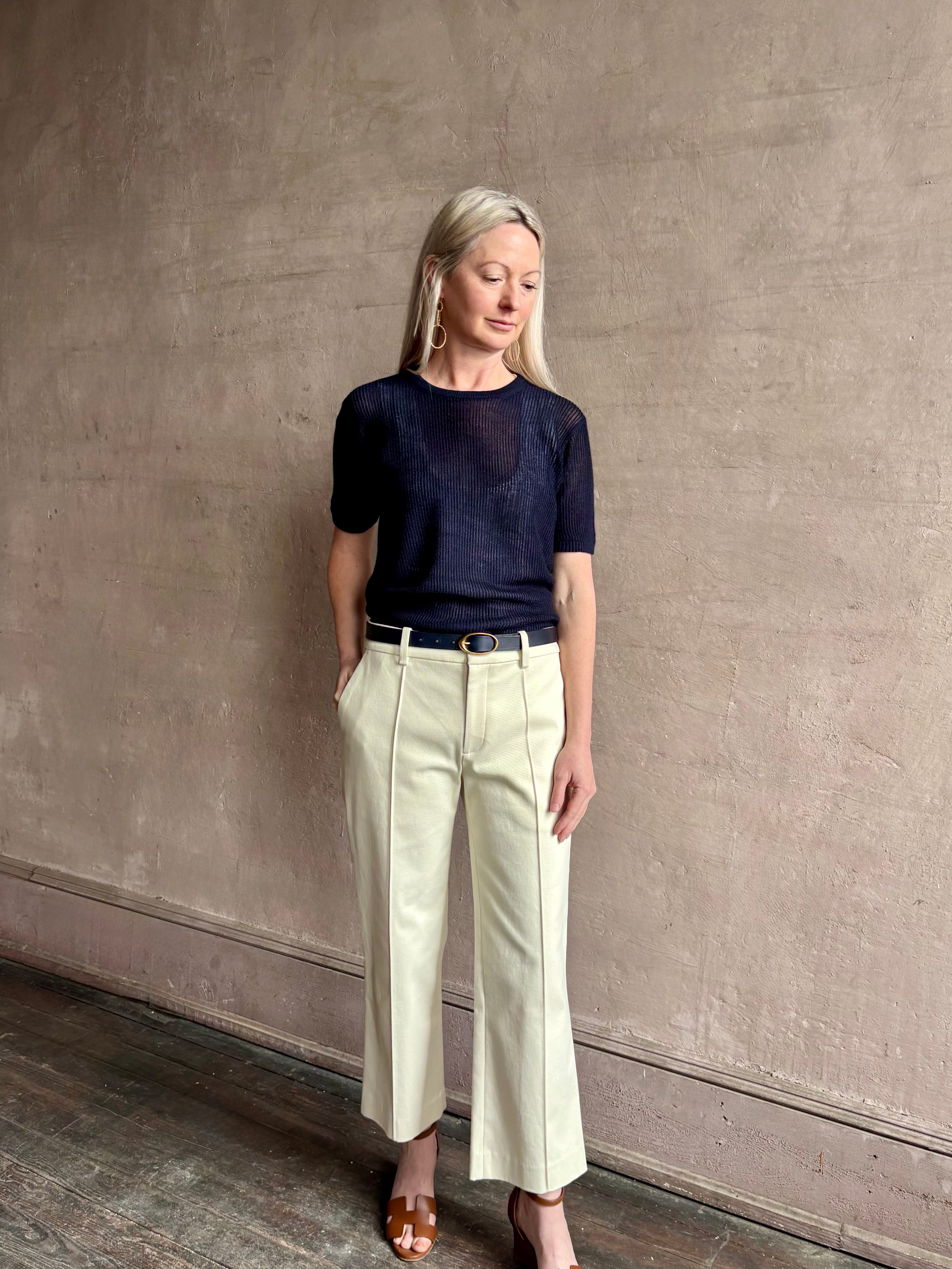 Mature woman wearing luxury Short Sleeve navy blue cashmere Tee Sweater from TWP with open weave and crew neck