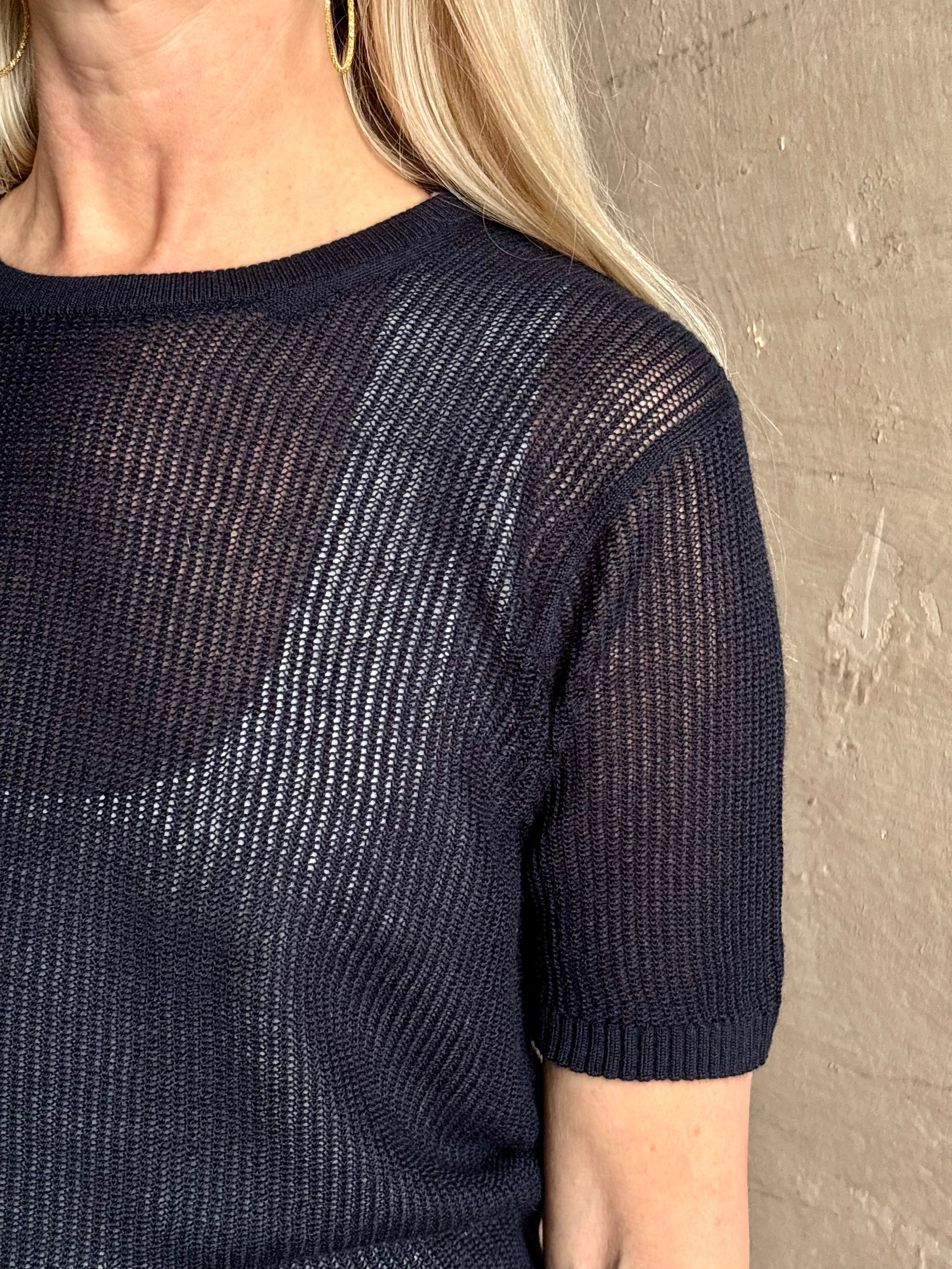 Mature woman wearing luxury Short Sleeve navy blue cashmere Tee Sweater from TWP with open weave and crew neck