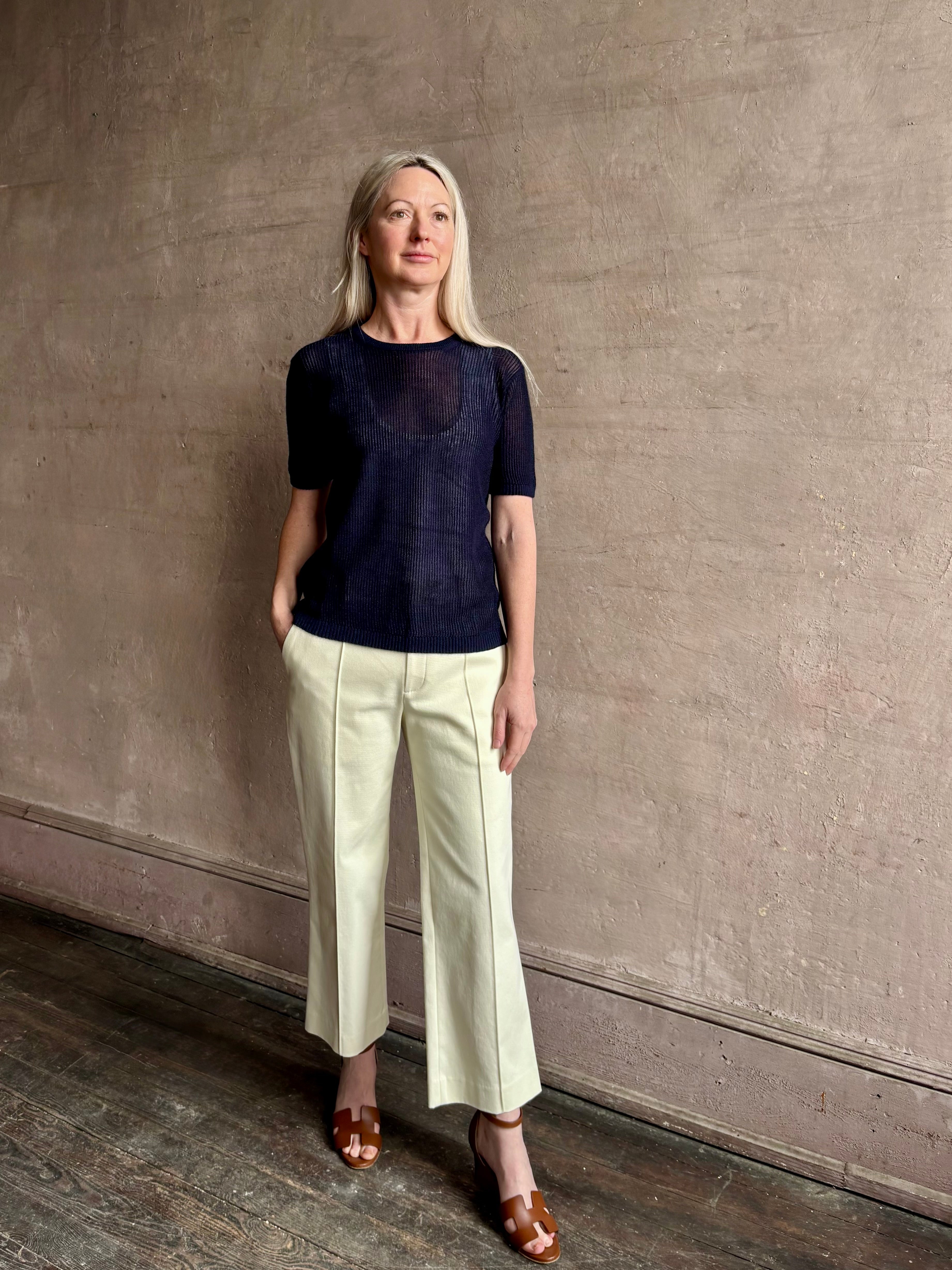 Mature woman wearing luxury Short Sleeve navy blue cashmere Tee Sweater from TWP with open weave and crew neck