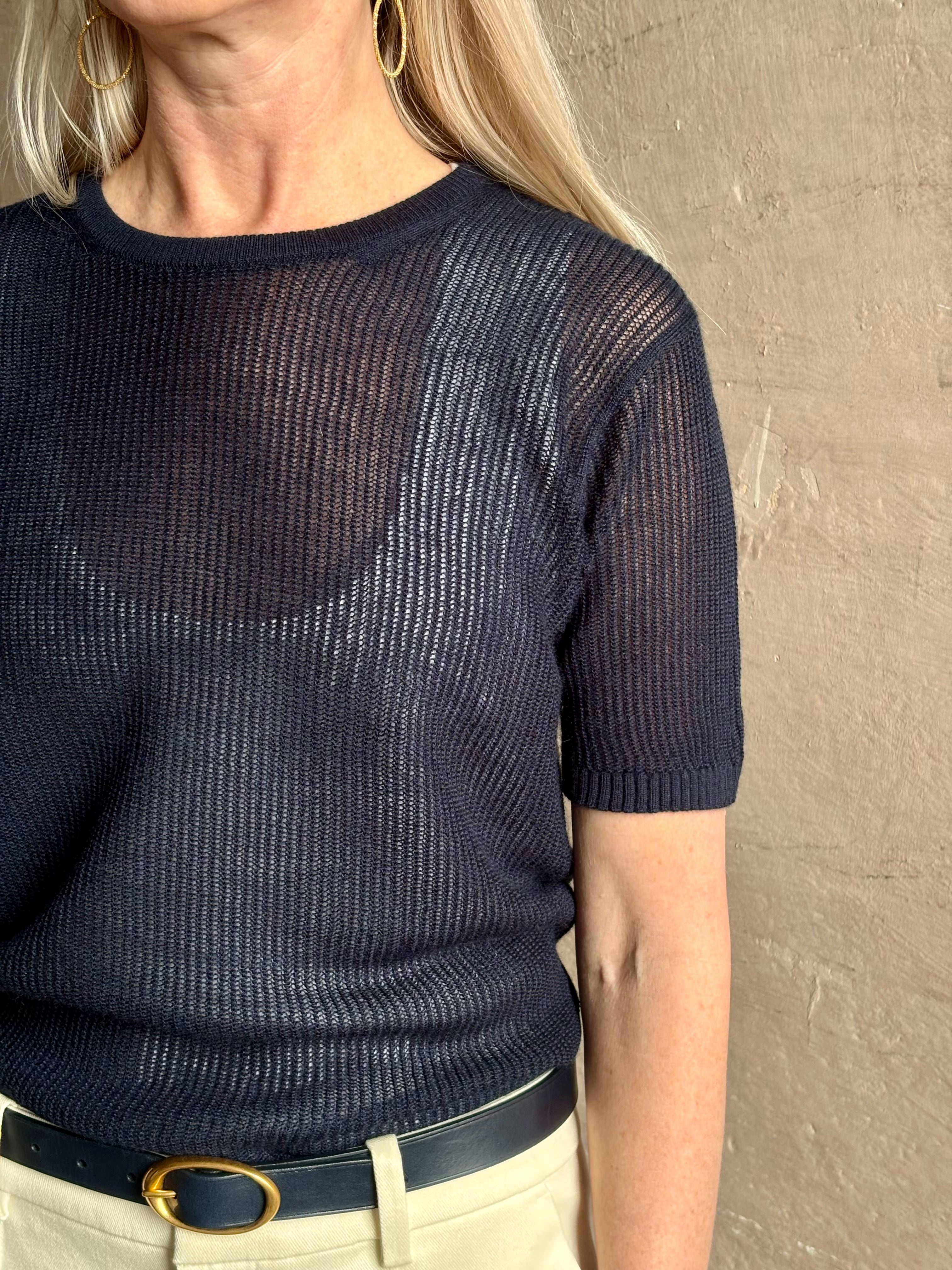 Mature woman wearing luxury Short Sleeve navy blue cashmere Tee Sweater from TWP with lightweight open weave and crew neckline
