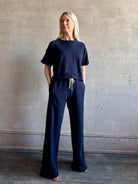 Mature woman waring the Slouchy Rolled Tee Top from TWP luxury women's designer tee rendered in a versatile navy blue and crafted from 100% cotton with short sleeves and crew neckline