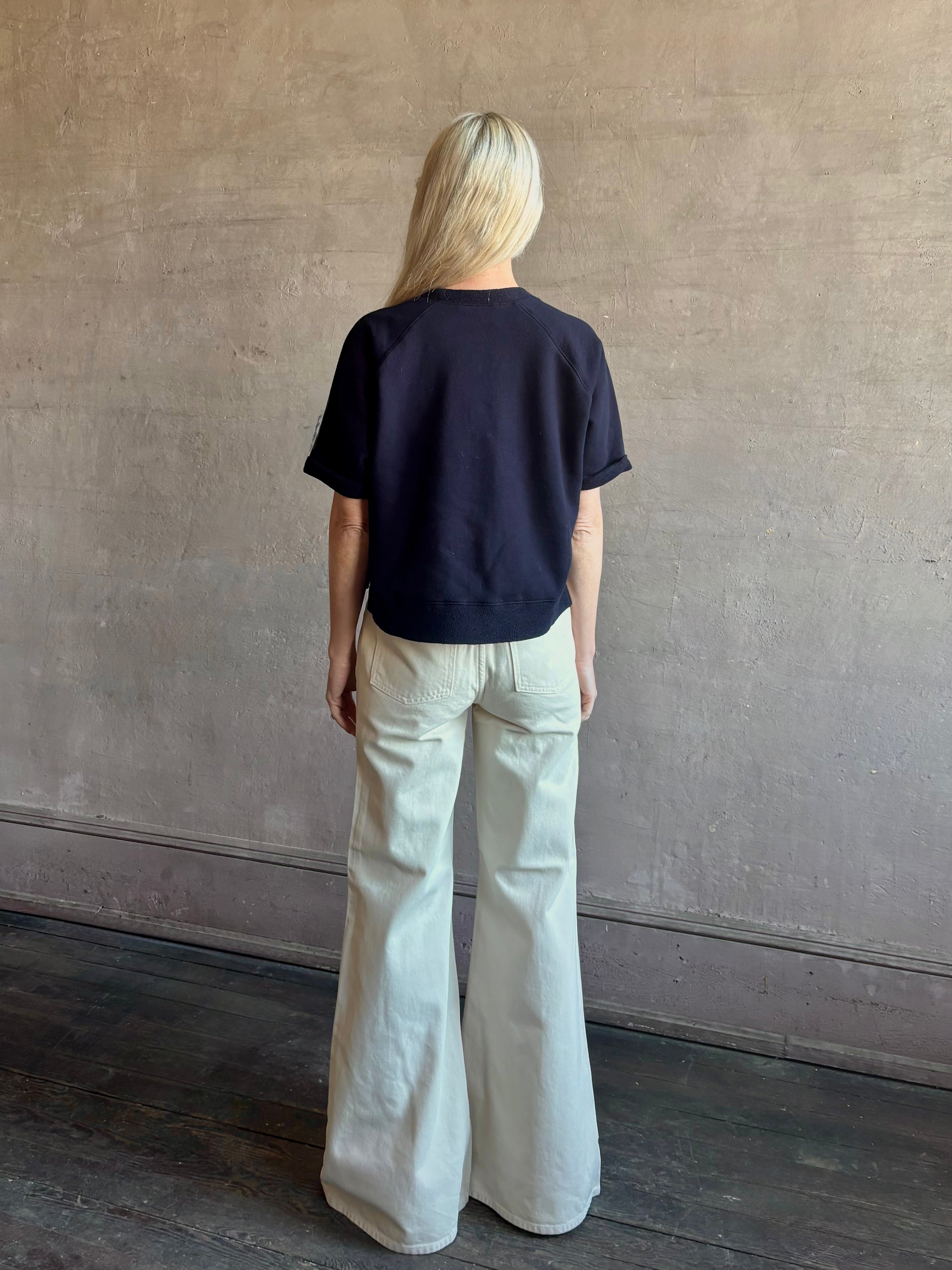 Mature woman waring the Slouchy Rolled Tee Top from TWP luxury women's designer tee rendered in a versatile navy blue and crafted from 100% cotton with short sleeves and crew neckline