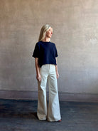 Mature woman waring the Slouchy Rolled Tee Top from TWP luxury women's designer tee rendered in a versatile navy blue and crafted from 100% cotton with short sleeves and crew neckline