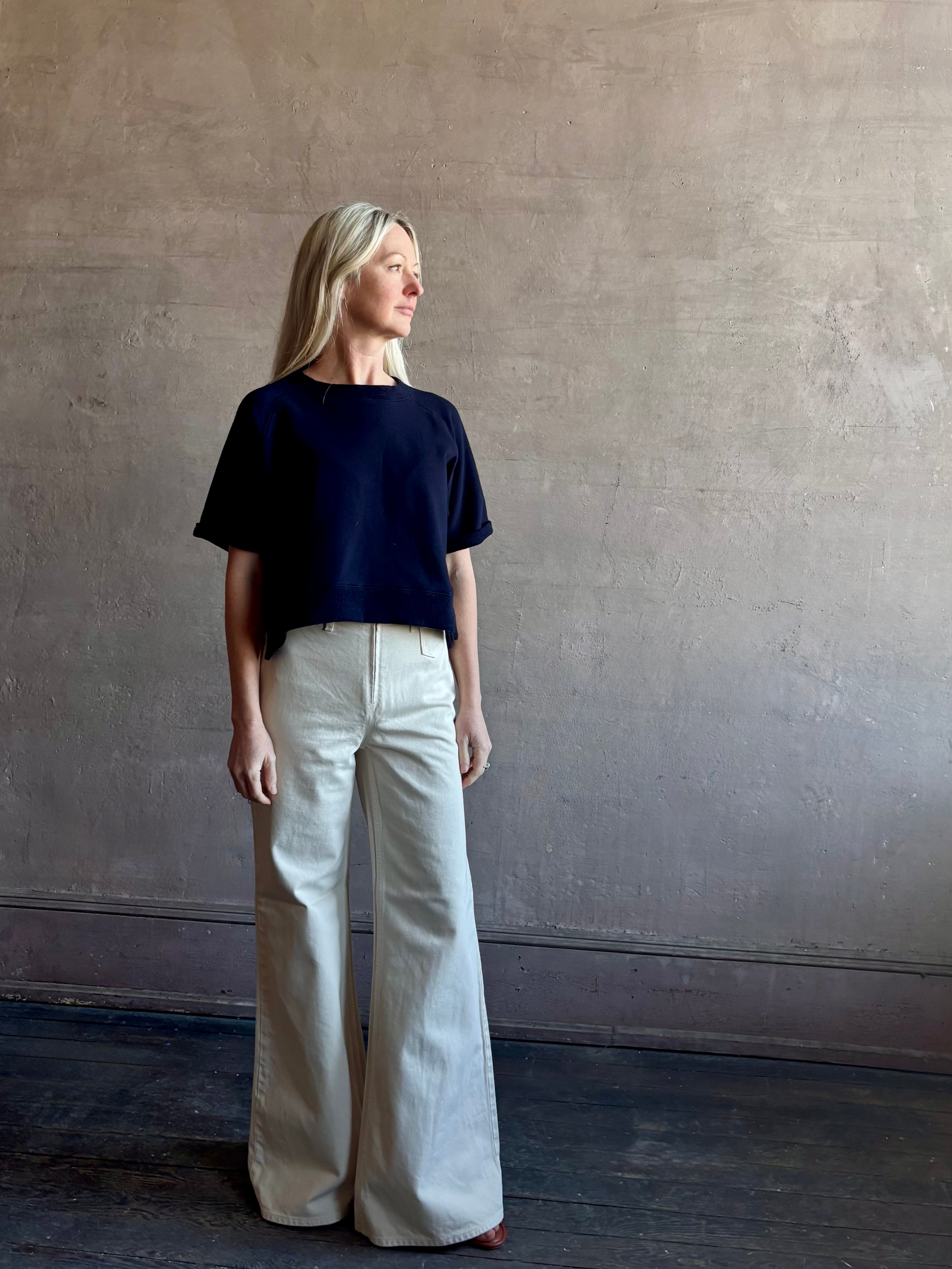 Mature woman waring the Slouchy Rolled Tee Top from TWP luxury women's designer tee rendered in a versatile navy blue and crafted from 100% cotton with short sleeves and crew neckline