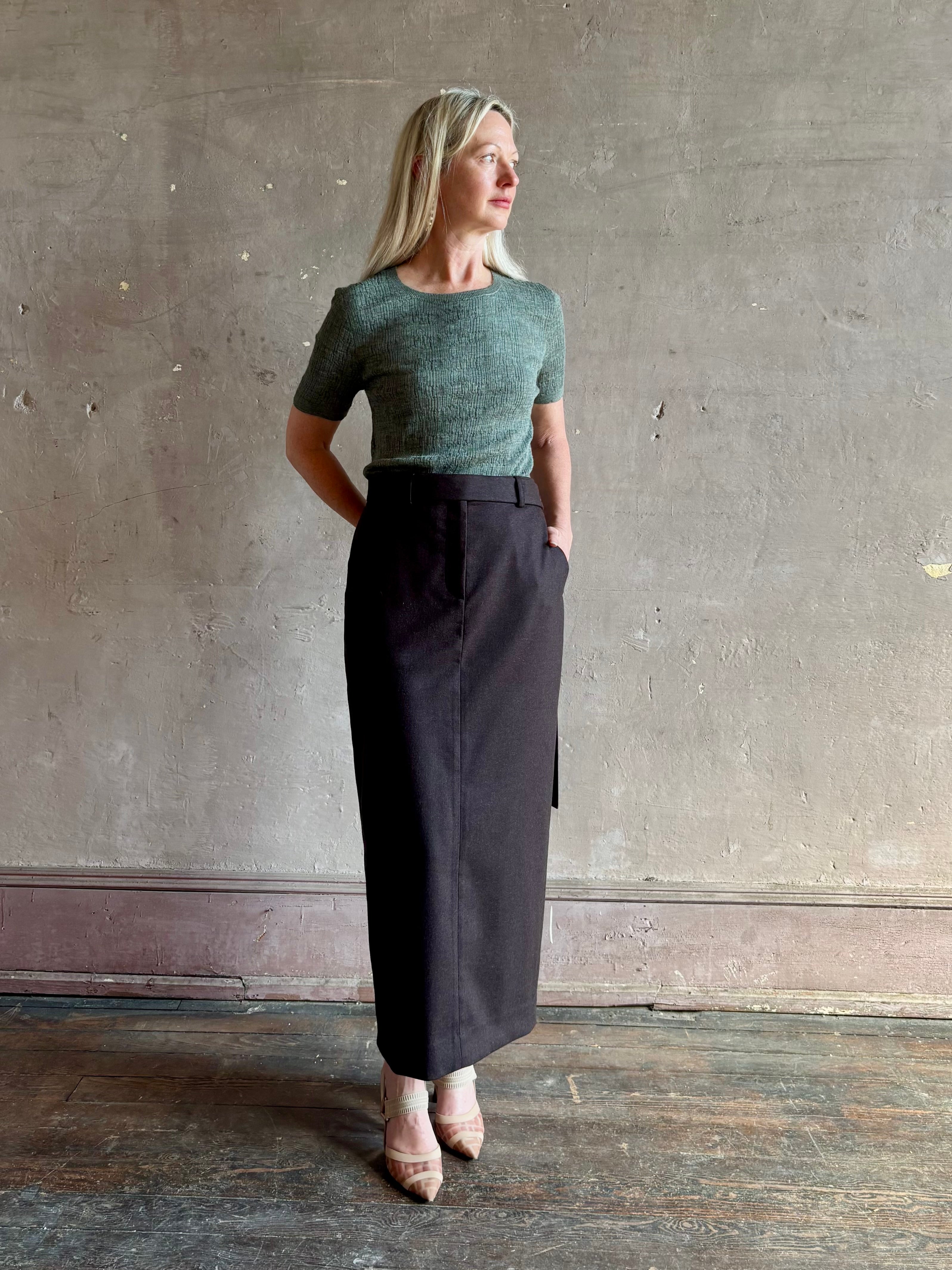 Mature woman wearing TWP Slit Pencil Skirt in Chocolate Brown a sophisticated wool-cashmere blend with tailored waist and front zipper and hook and bar closure 