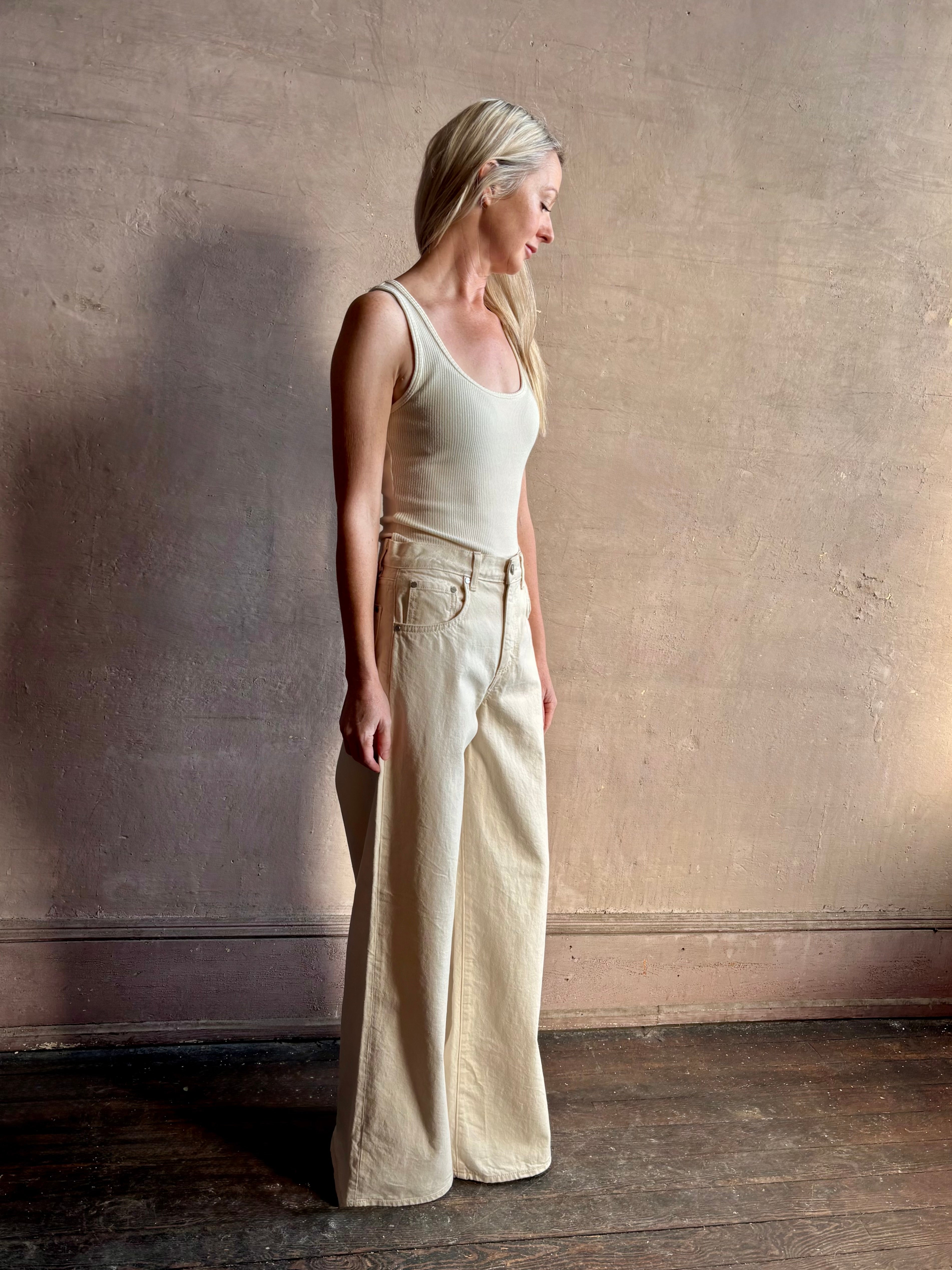 Mature woman wearing premium cotton TWP Tiny Dancer rigid denim with relaxed high rise and wide leg in Natural