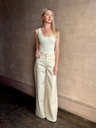 Mature woman wearing premium cotton TWP Tiny Dancer rigid denim with relaxed high rise and wide leg in Natural
