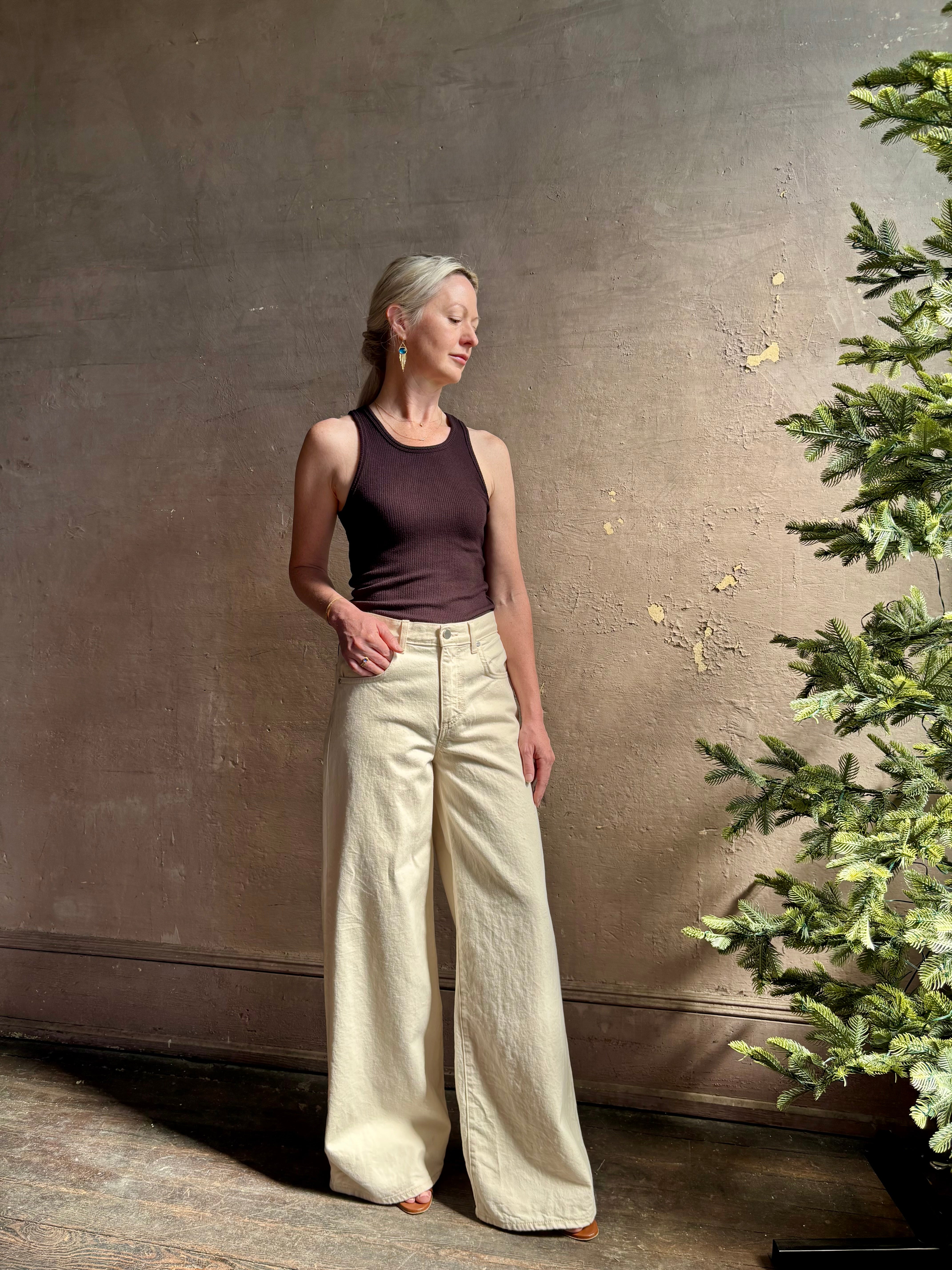 Mature woman wearing premium cotton TWP Tiny Dancer rigid denim with relaxed high rise and wide leg in Natural