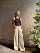 Mature woman wearing premium cotton TWP Tiny Dancer rigid denim with relaxed high rise and wide leg in Natural