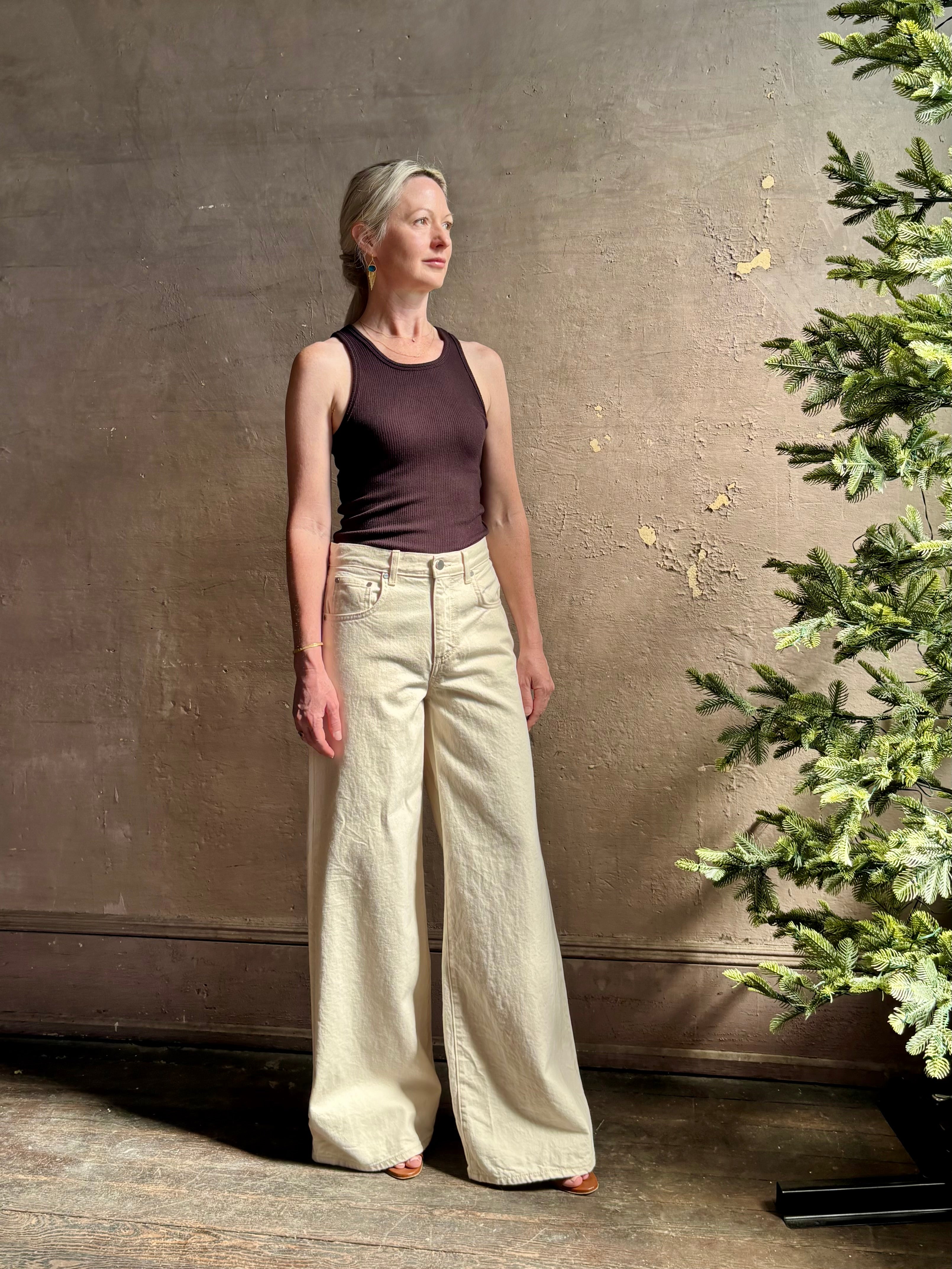 Mature woman wearing premium cotton TWP Tiny Dancer rigid denim with relaxed high rise and wide leg in Natural