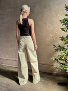 Mature woman wearing premium cotton TWP Tiny Dancer rigid denim with relaxed high rise and wide leg in Natural