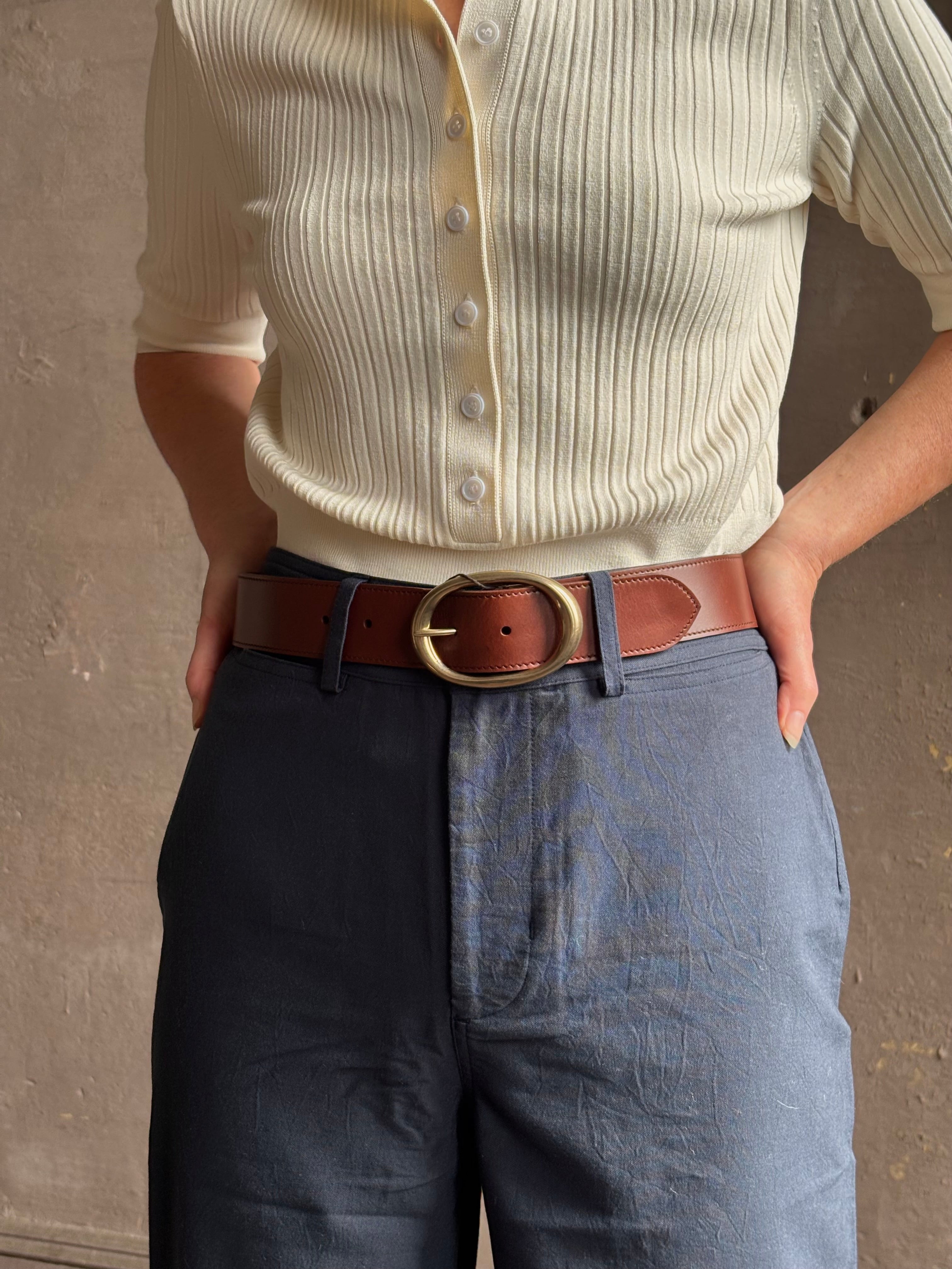 Mature woman wearing a TWP bourbon brown wide leather belt with warm gold tone oval buckle