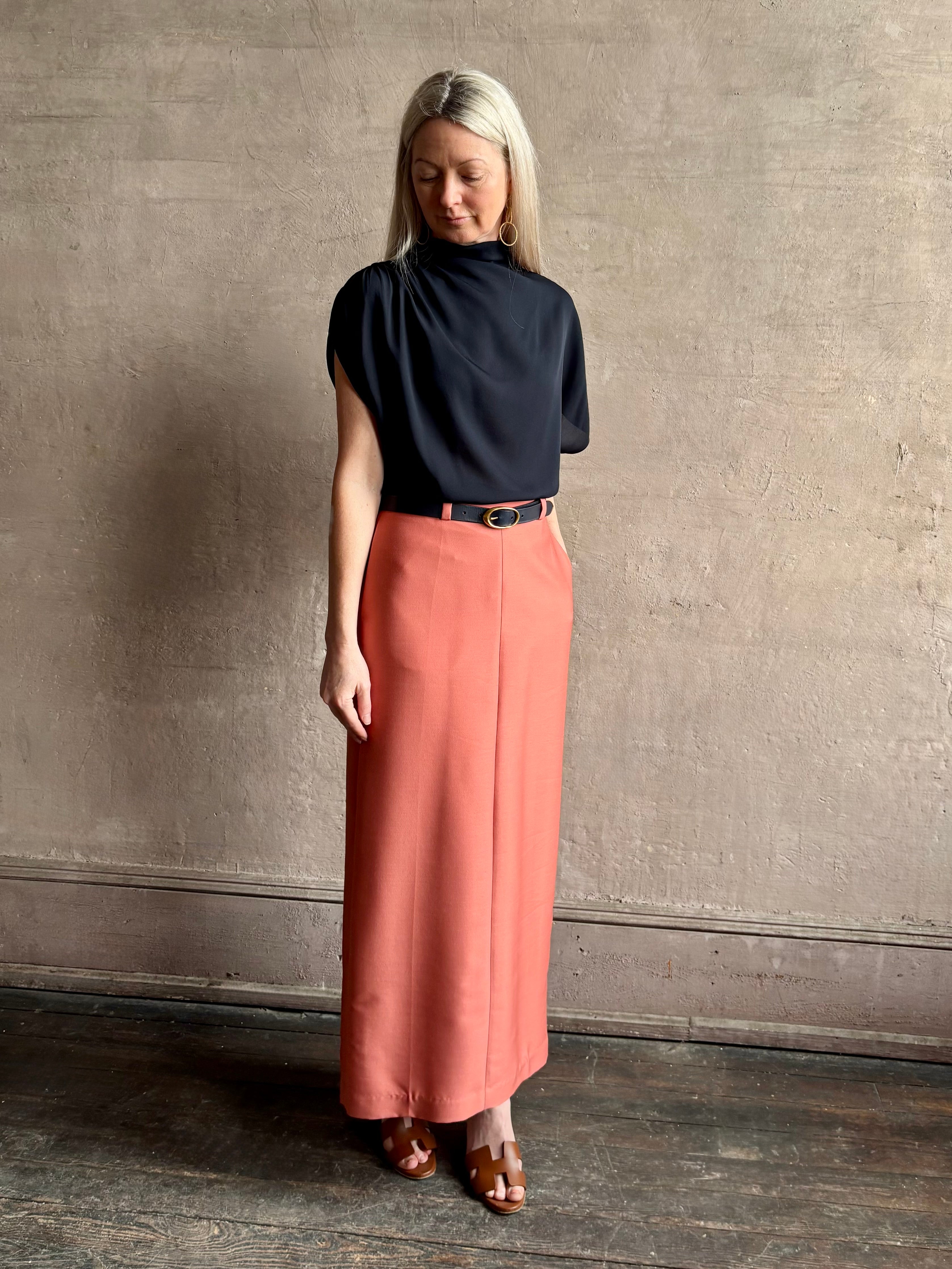 Mature woman wearing an asymmetrical navy blue silk blouse by New York luxury Women's clothing designer TWP with short sleeves