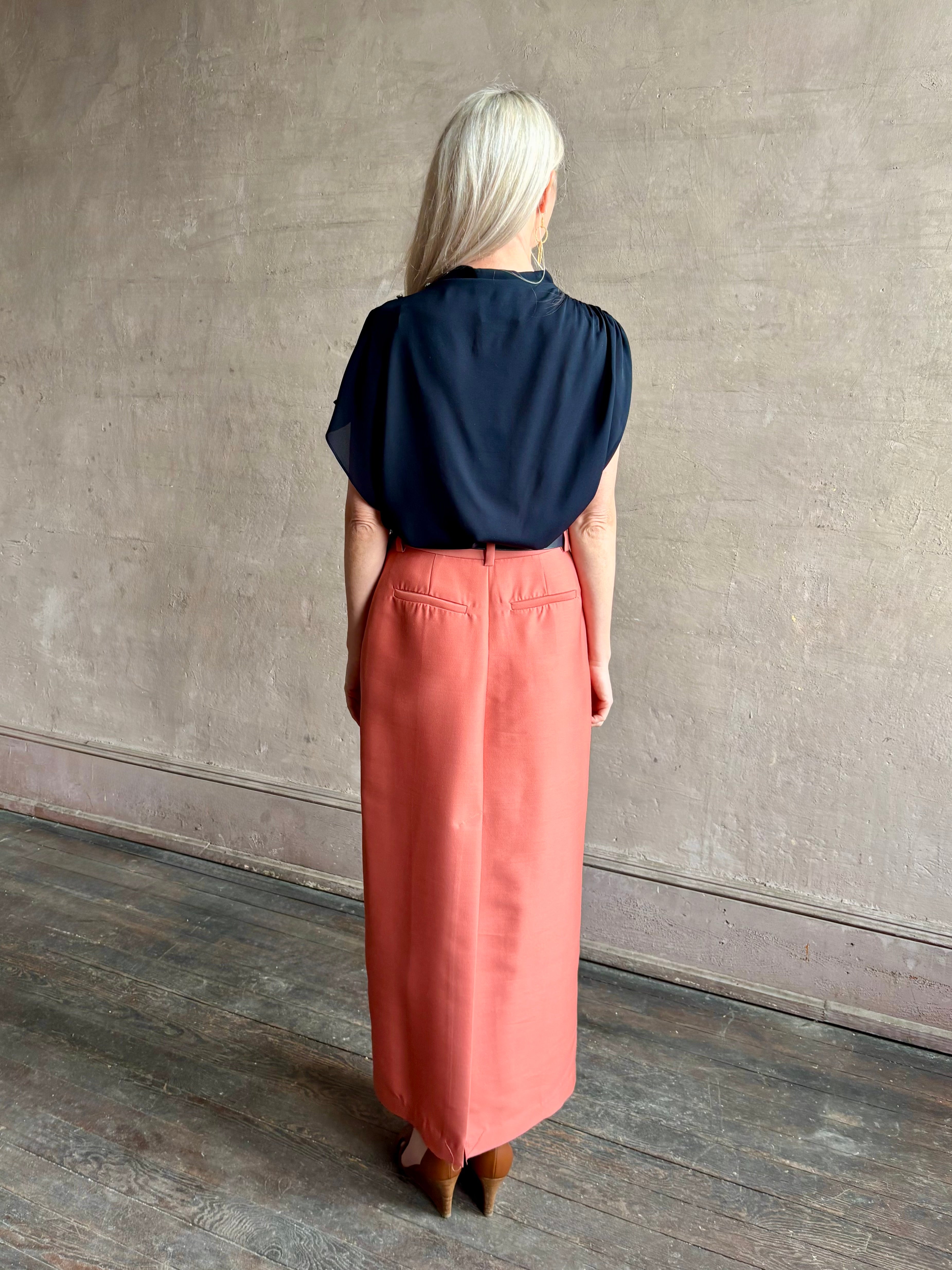 Mature woman wearing an asymmetrical navy blue silk blouse by New York luxury Women's clothing designer TWP with short sleeves 