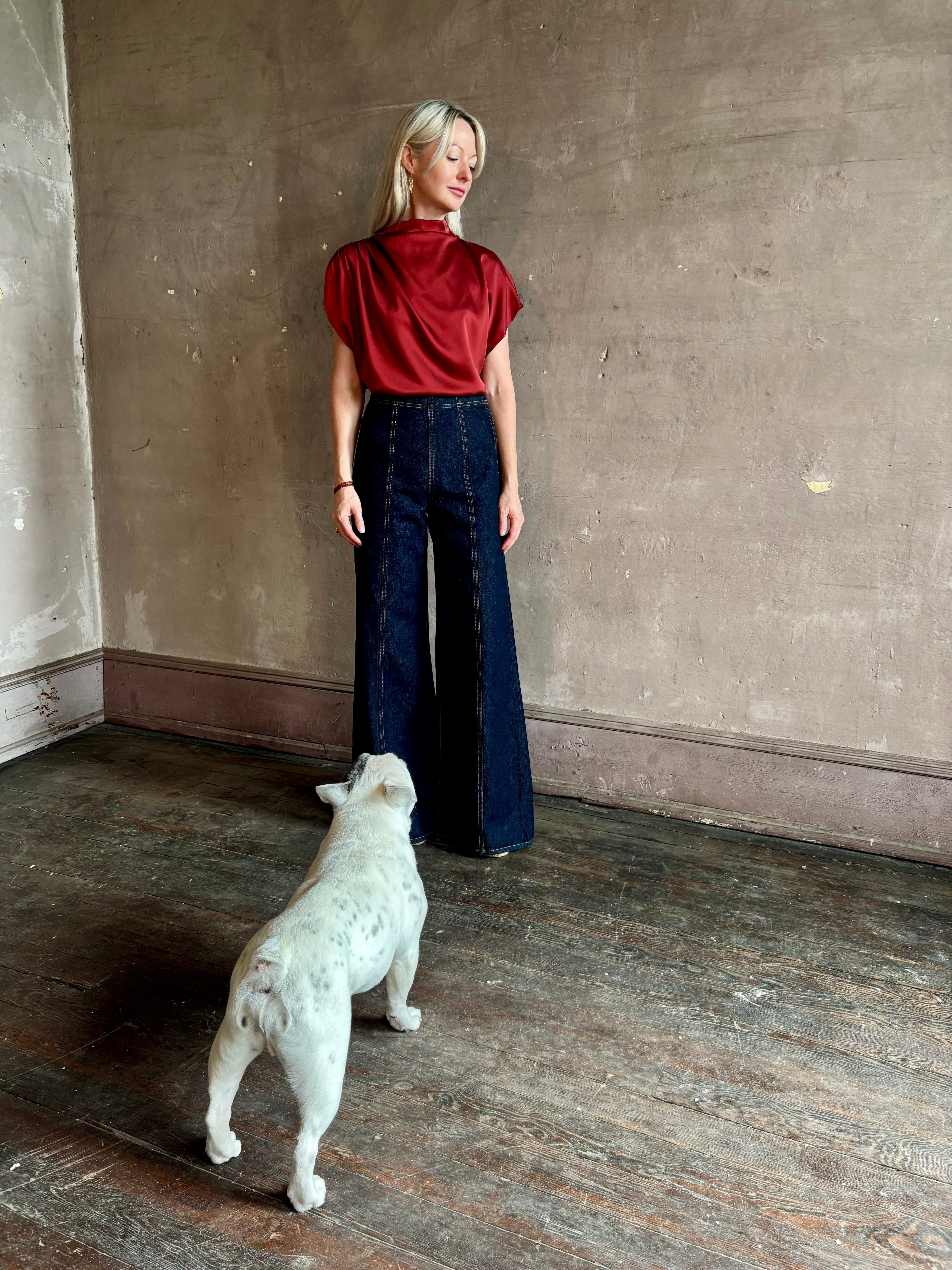 Mature woman wearing Wish You Would blouse from TWP rendered in a rich currant red and crafted from a luxurious silk blend with a mock neck,  asymetrical design and draping short sleeves shoulder button closure