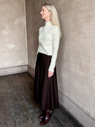 Woman wearing TWP Willow Knit Skirt in chocolate brown premium Merino Wool Knit A-line Skirt
