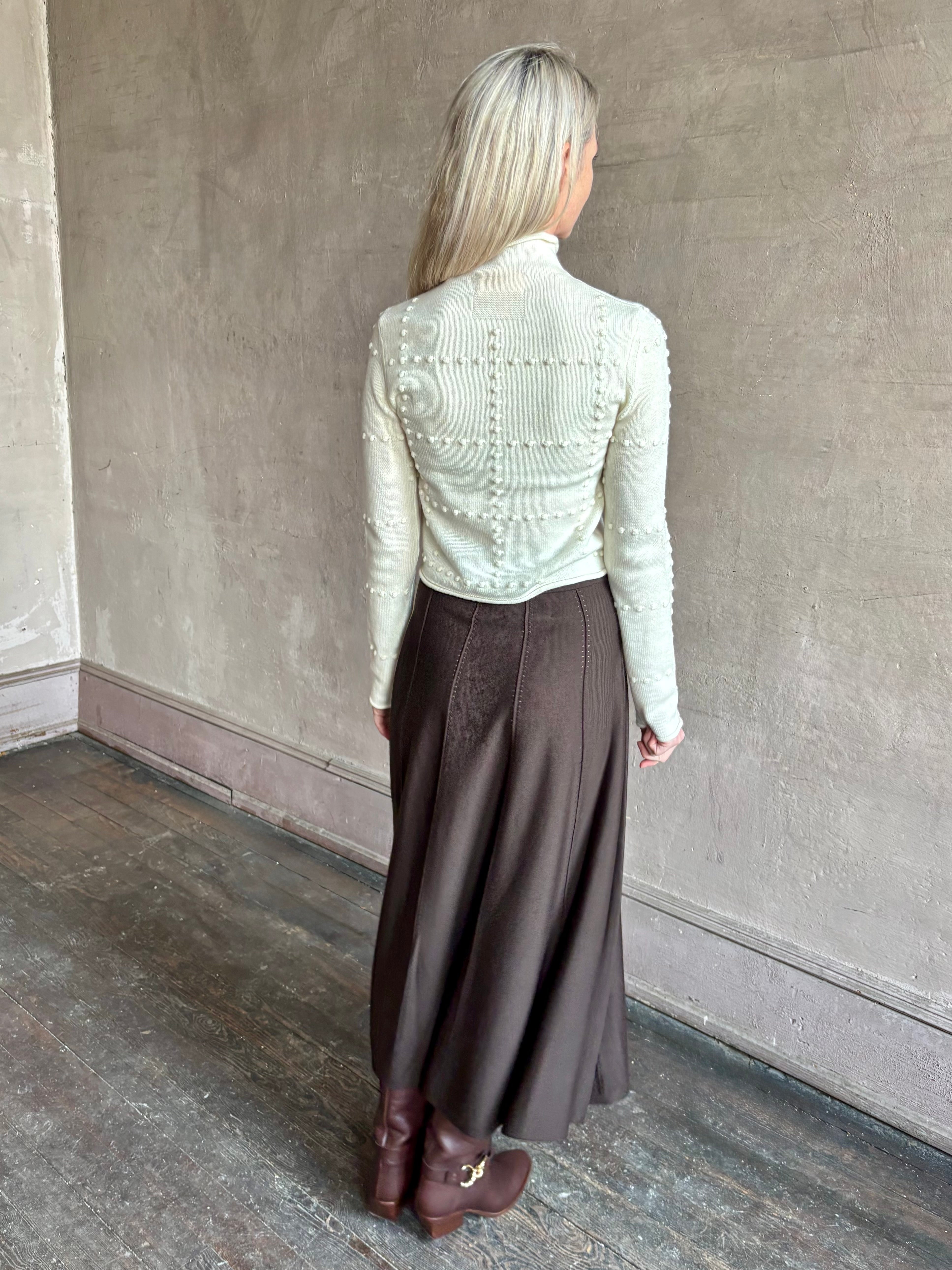 Woman wearing TWP Willow Knit Skirt in chocolate brown premium Merino Wool Knit A-line Skirt