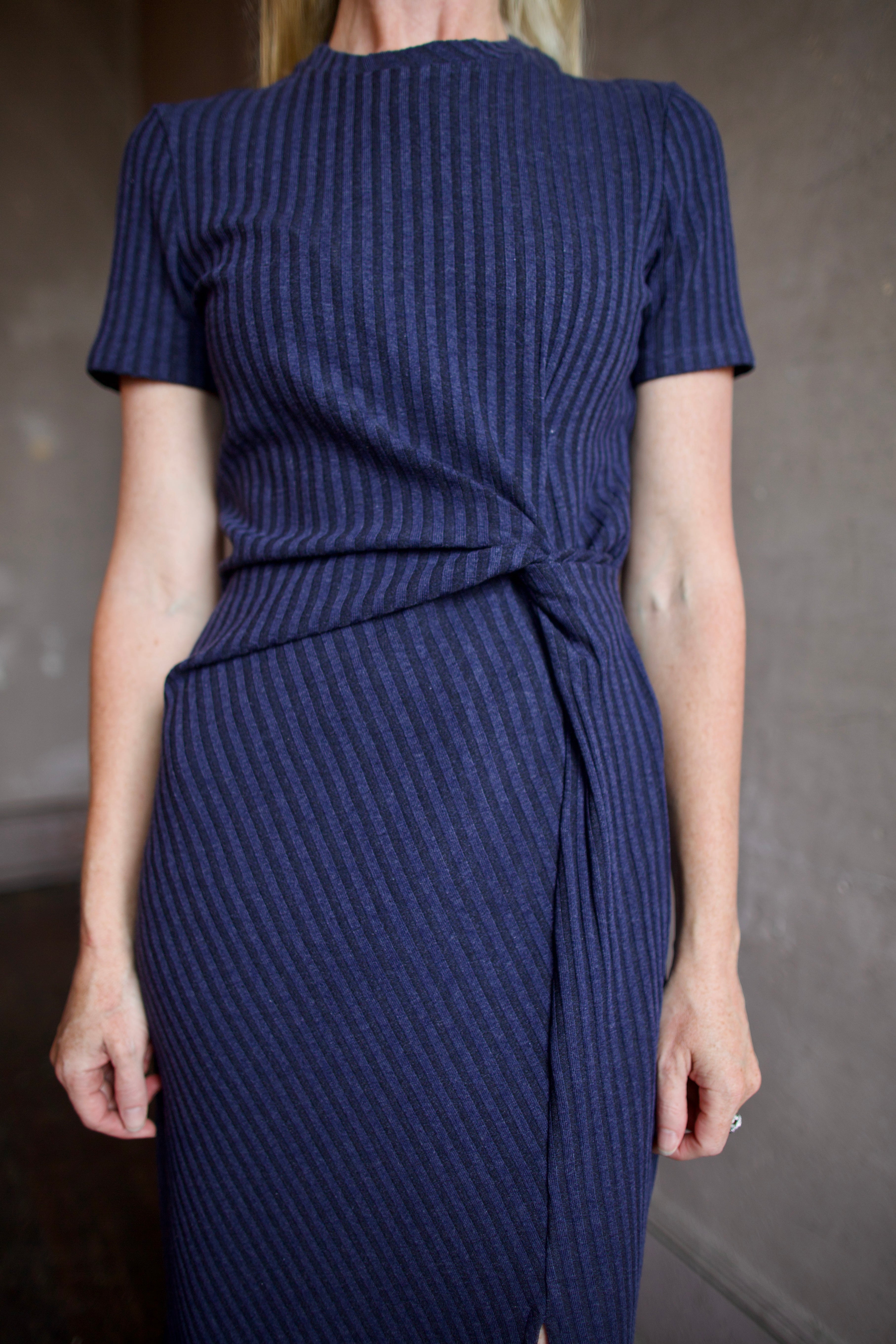 Model wearing a timeless comfortable cotton blue dress with a twist front detail by designer Tanya Taylor