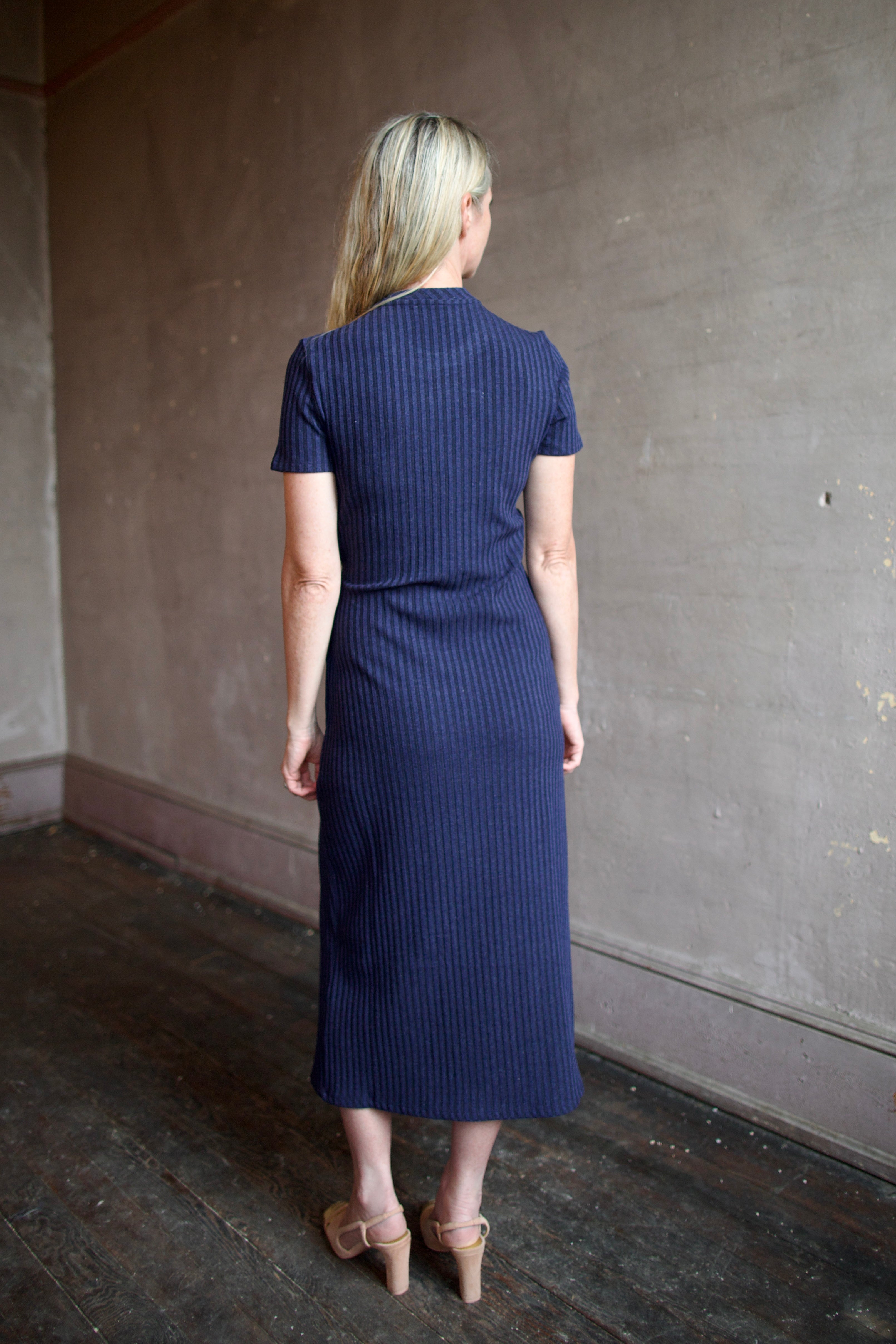 Model wearing a flattering elevated casual ribbed blue and black dress by designer Tanya Taylor