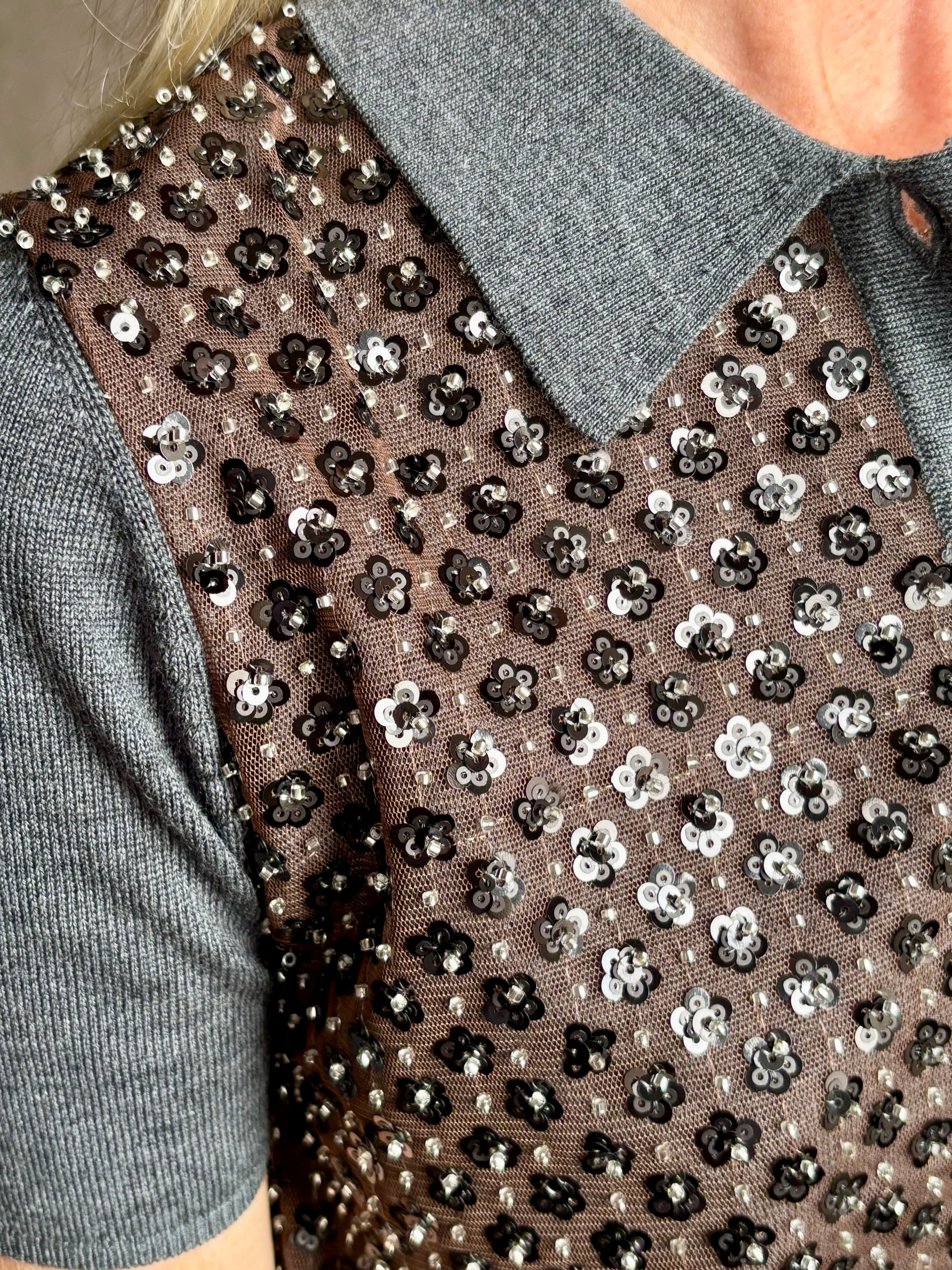 Close-up image of American designer Tanya Taylor Camilla Knit top with a brown sequin floral patterned over a gray extra fine merino wool polo sweater