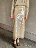 Image of mature woman wearing designer Tanya Taylor Kiah sequin maxi-length pencil skirt with flattering fit and in a neutral beige colorway