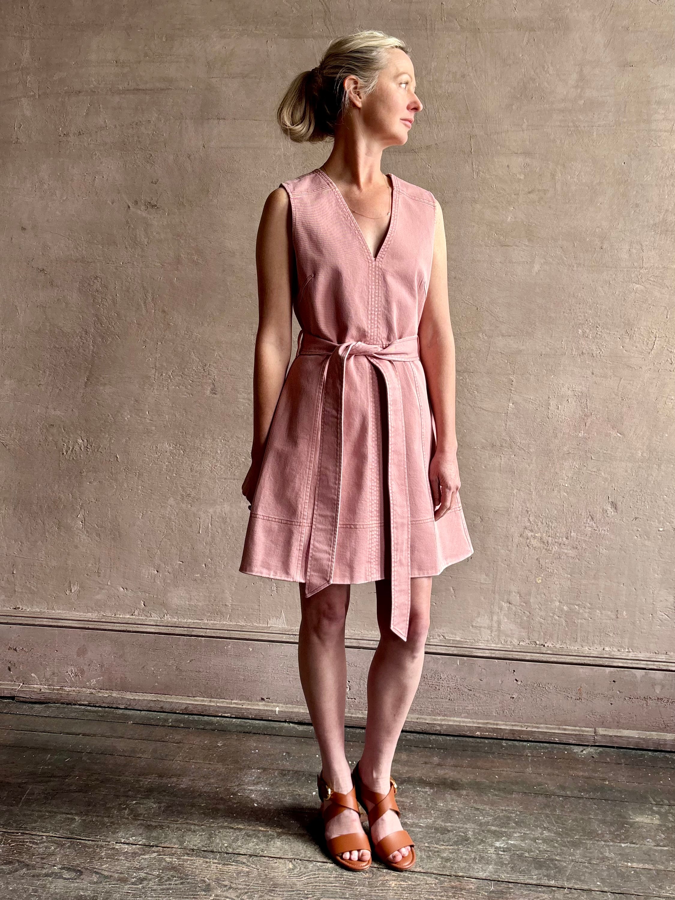 mature woman wearing designer Tanya Taylor Reina cotton denim short sleeveless Dress in Roqua pink with v-neck