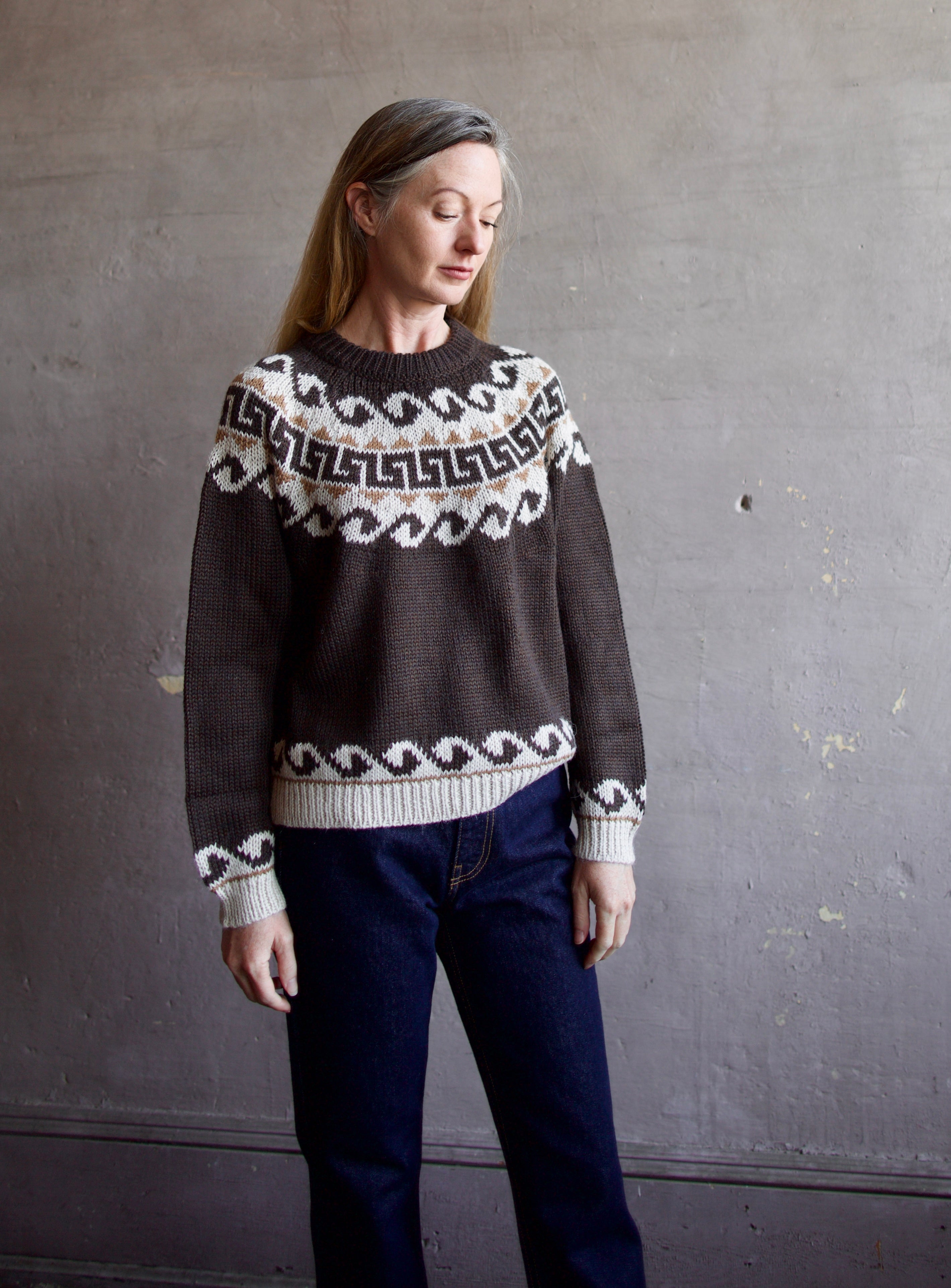 Image featuring a woman wearing the Great Greek Key brown pullover sweater with a khaki and cream pattern in the softest texture.