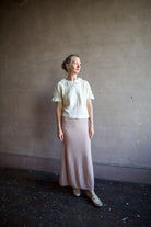 Image featuring a woman wearing the Rosebud top by The Great with a peter pan collar, ruffle lace detailing and a slightly tailored fit in cream color.