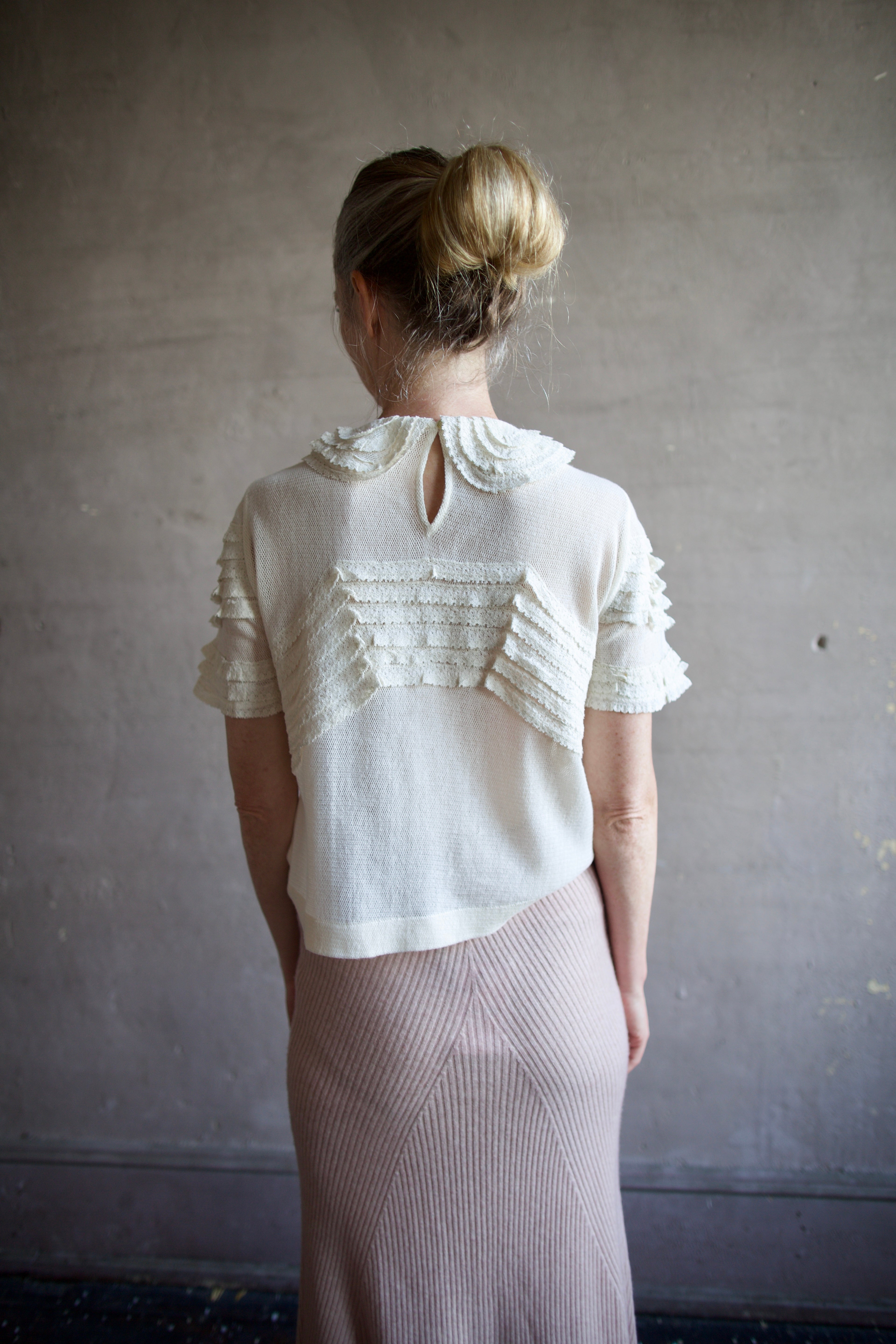 Image featuring a woman wearing the Rosebud top by The Great with a peter pan collar, ruffle lace detailing and a slightly tailored fit in cream color.