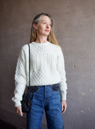 Mature woman wearing the Lara sweater by Trovata with a crew neckline and blocked woven texture in cream.