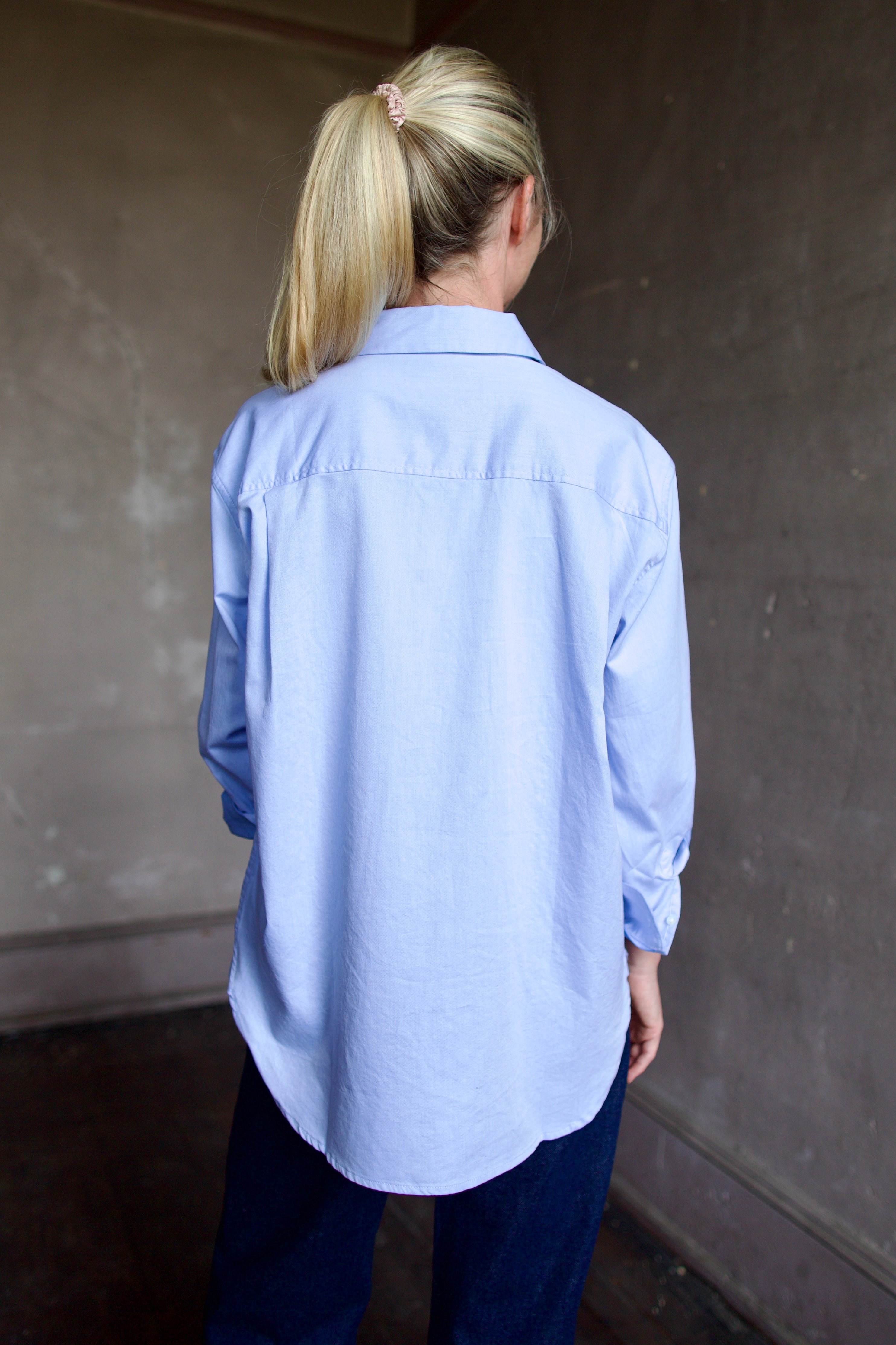 Image of model wearing the Blake light blue button-up shirt with a small embroidered design by Trovata